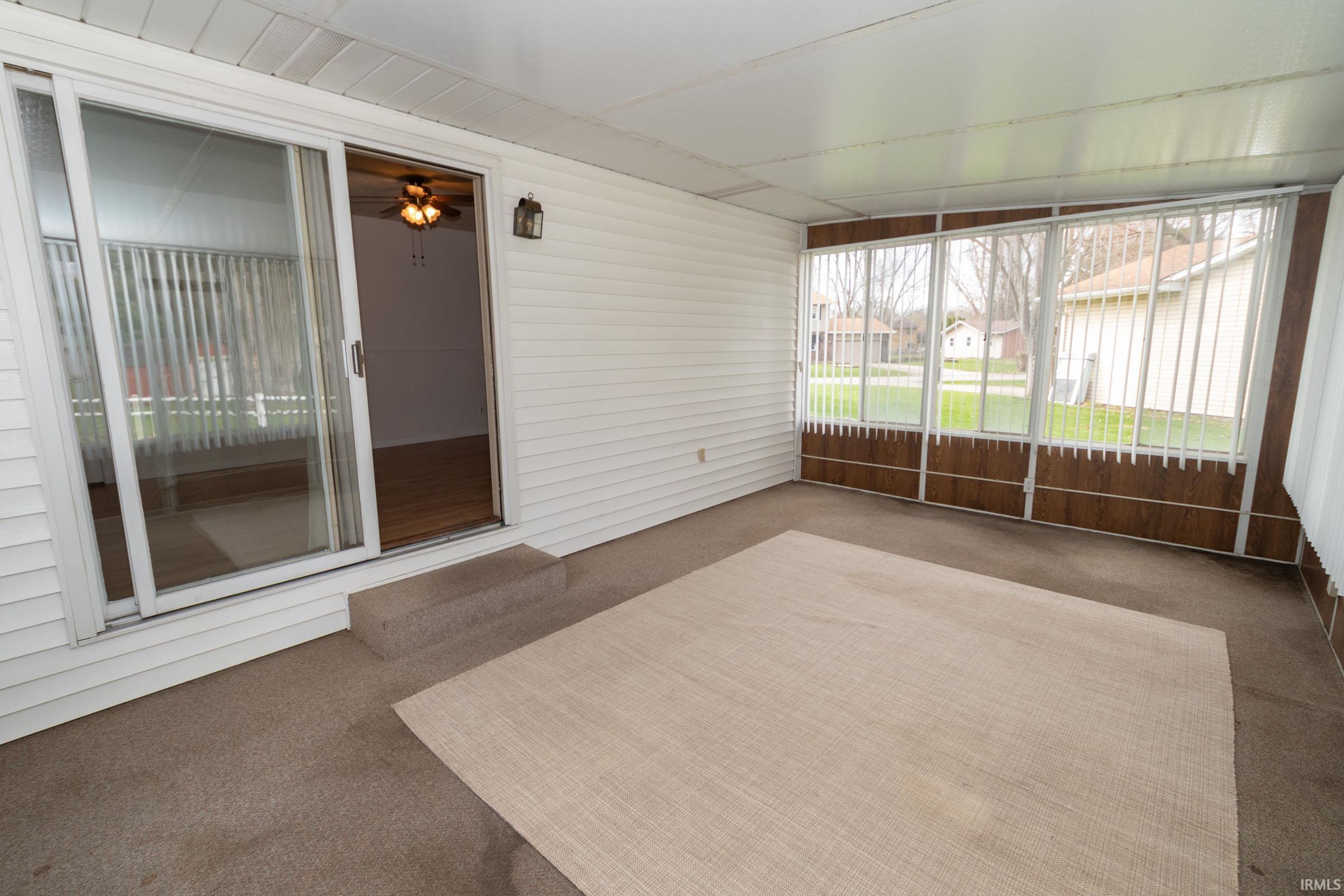 Unfurnished sunroom featuring a ceiling fan