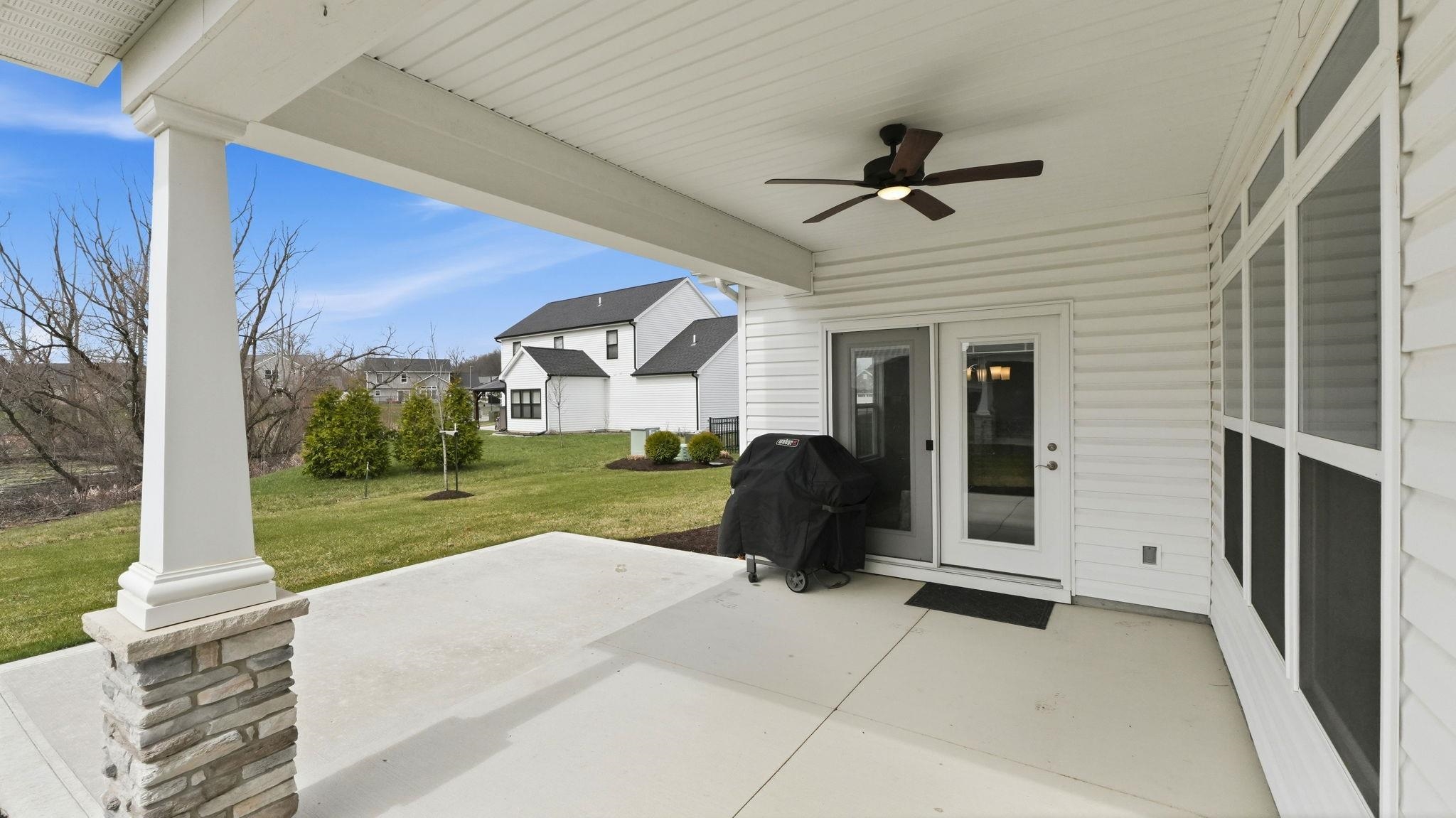 View of patio with ceiling fan and area for grilling