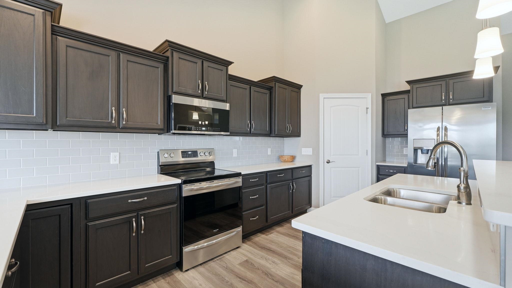 Kitchen with tasteful backsplash, hanging light fixtures