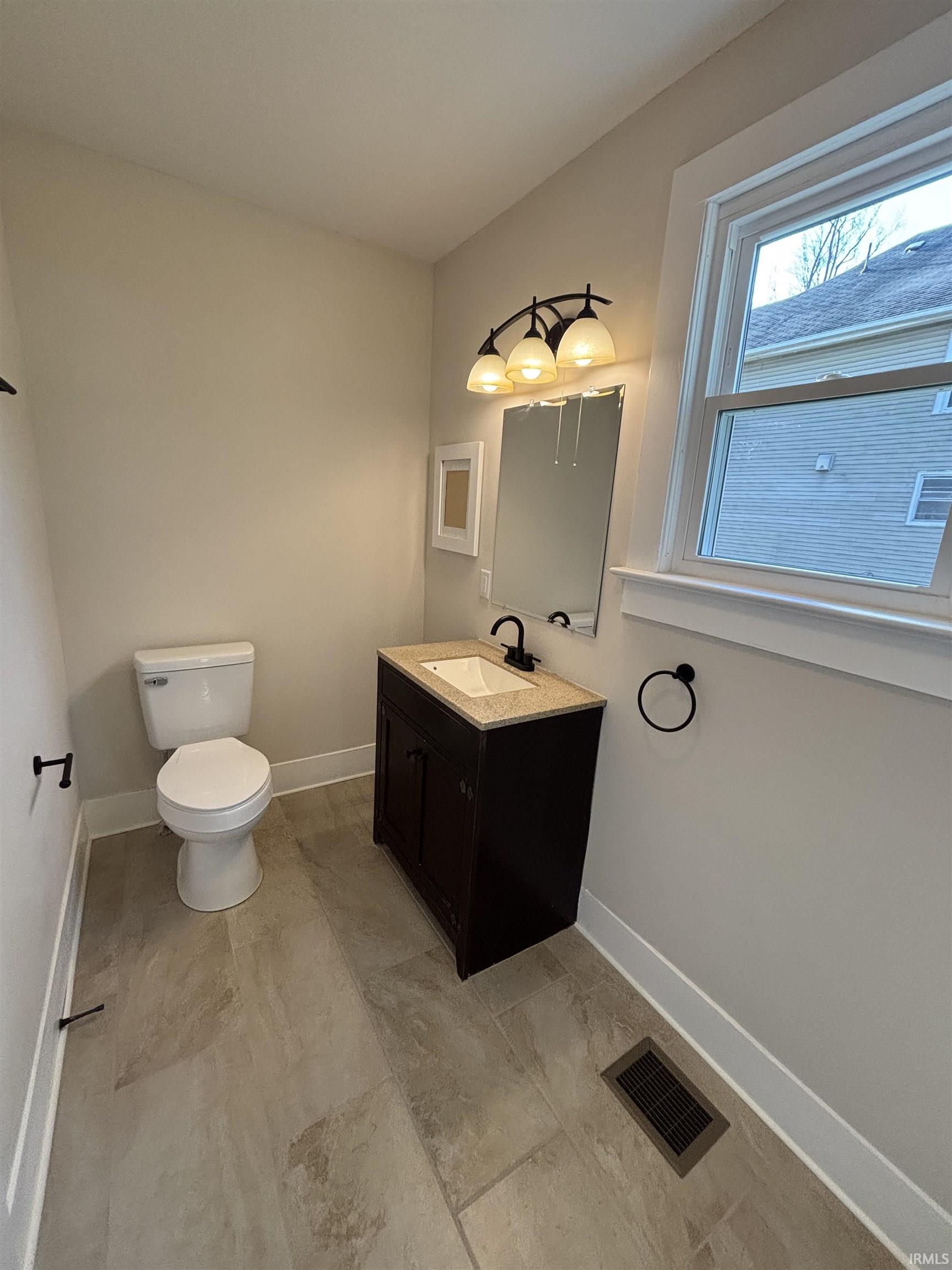 Half bathroom featuring vanity and toilet