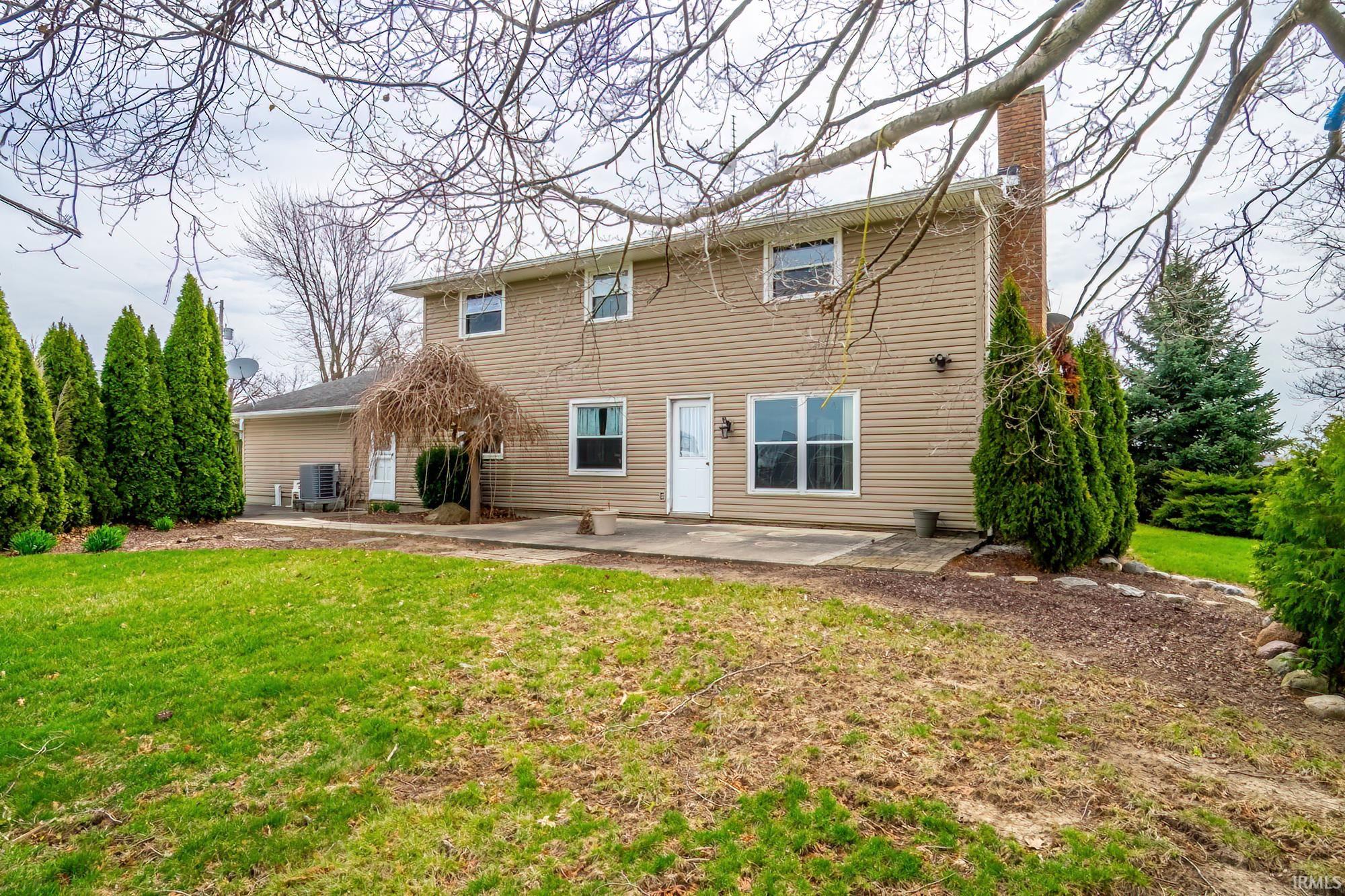 Back of property featuring a patio area, a chimney, and a yard