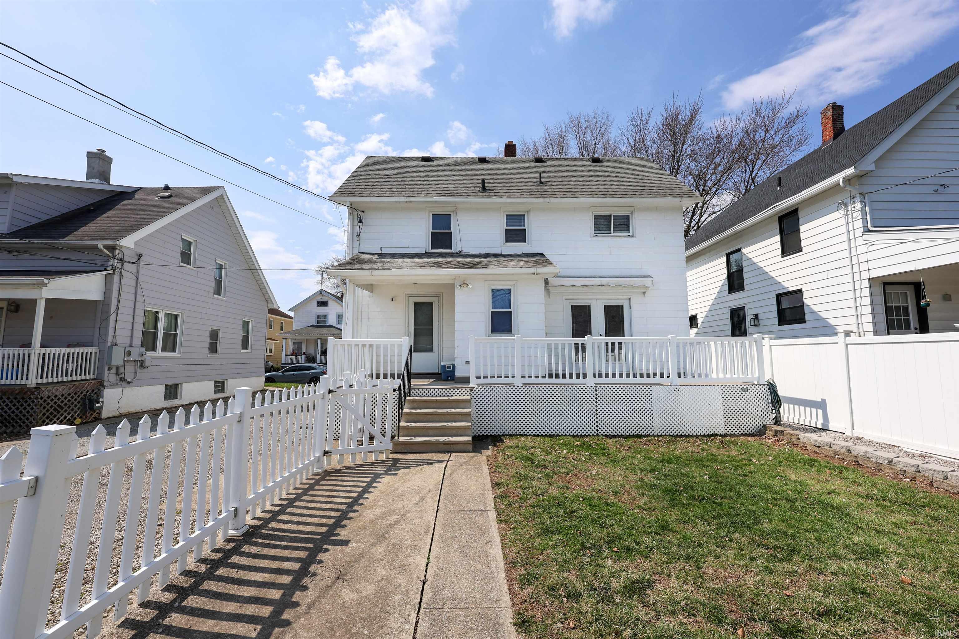 Rear view of property featuring a deck, a chimney, and a shingled roof