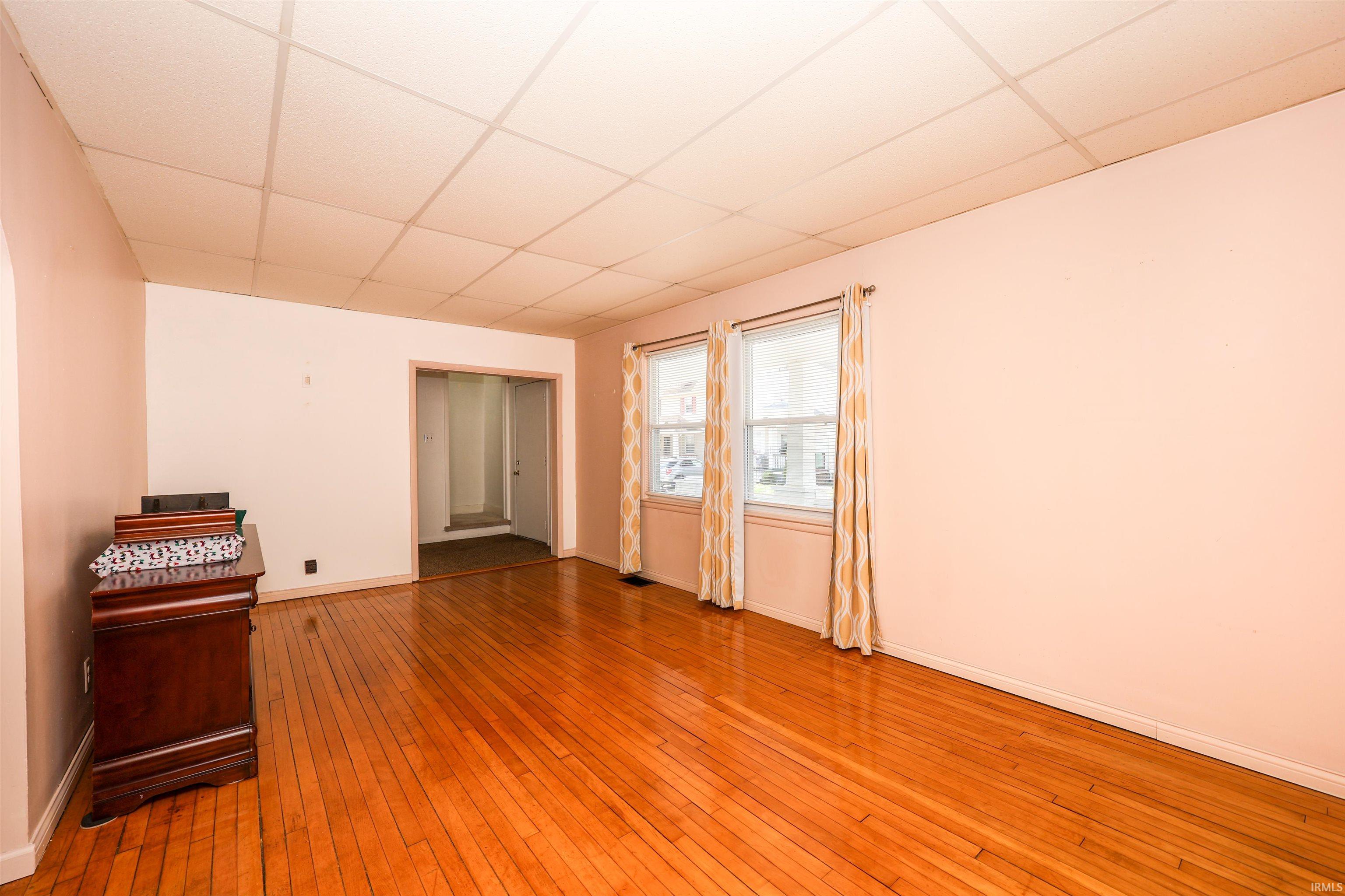 Spare room featuring a paneled ceiling and wood-type flooring