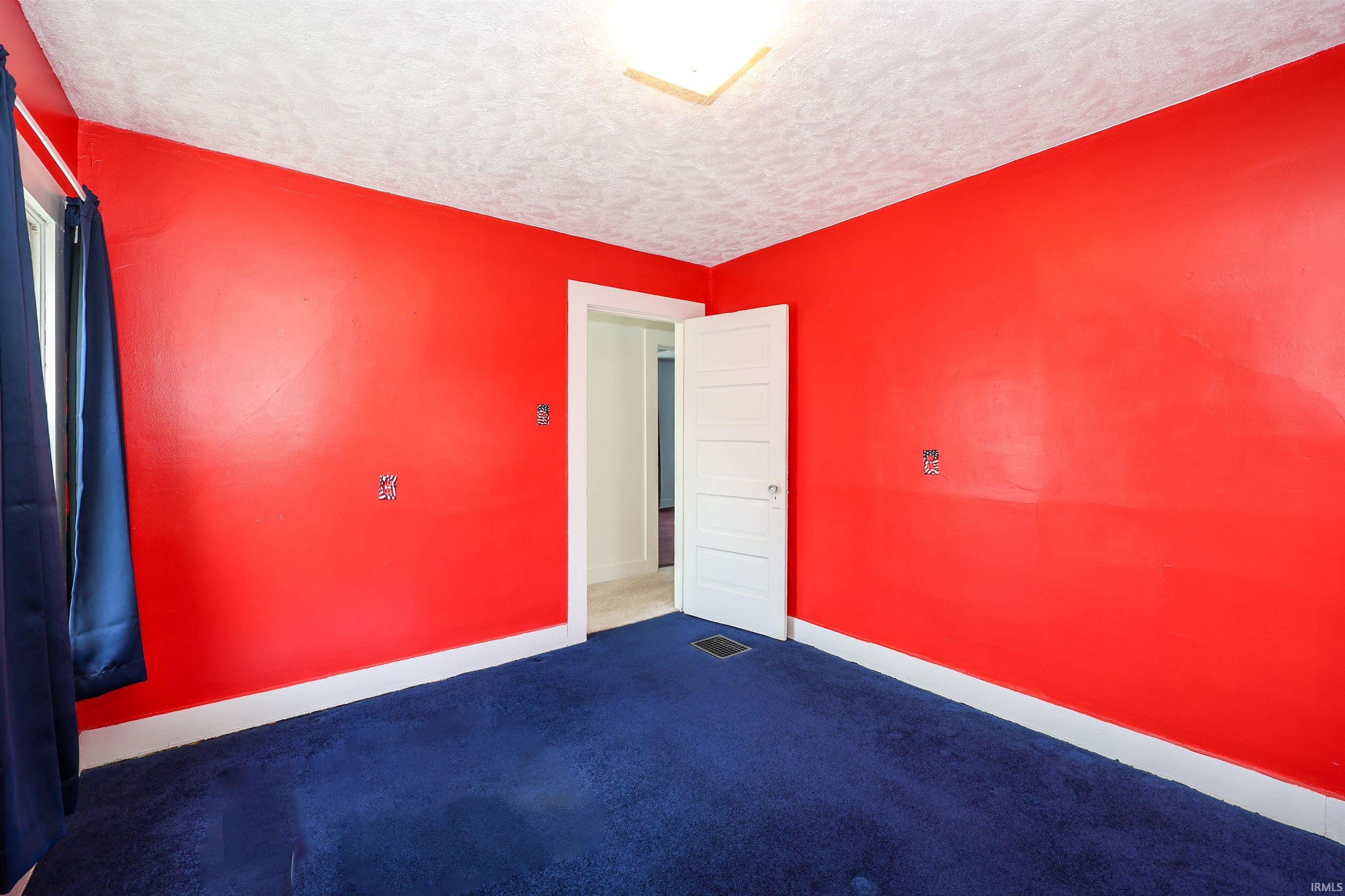 Spare room with dark carpet and a textured ceiling