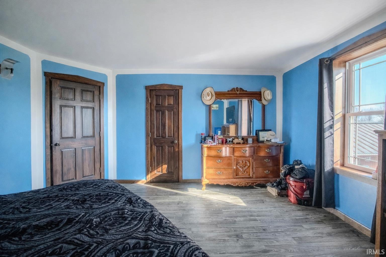 Bedroom featuring wood finished floors and baseboards
