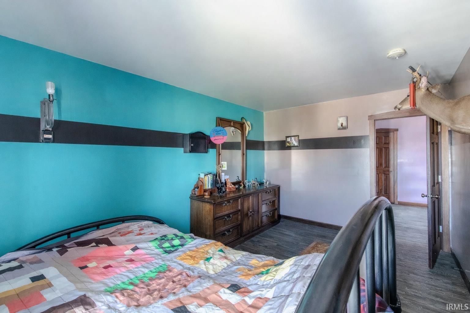 Bedroom featuring dark wood-type flooring and baseboards