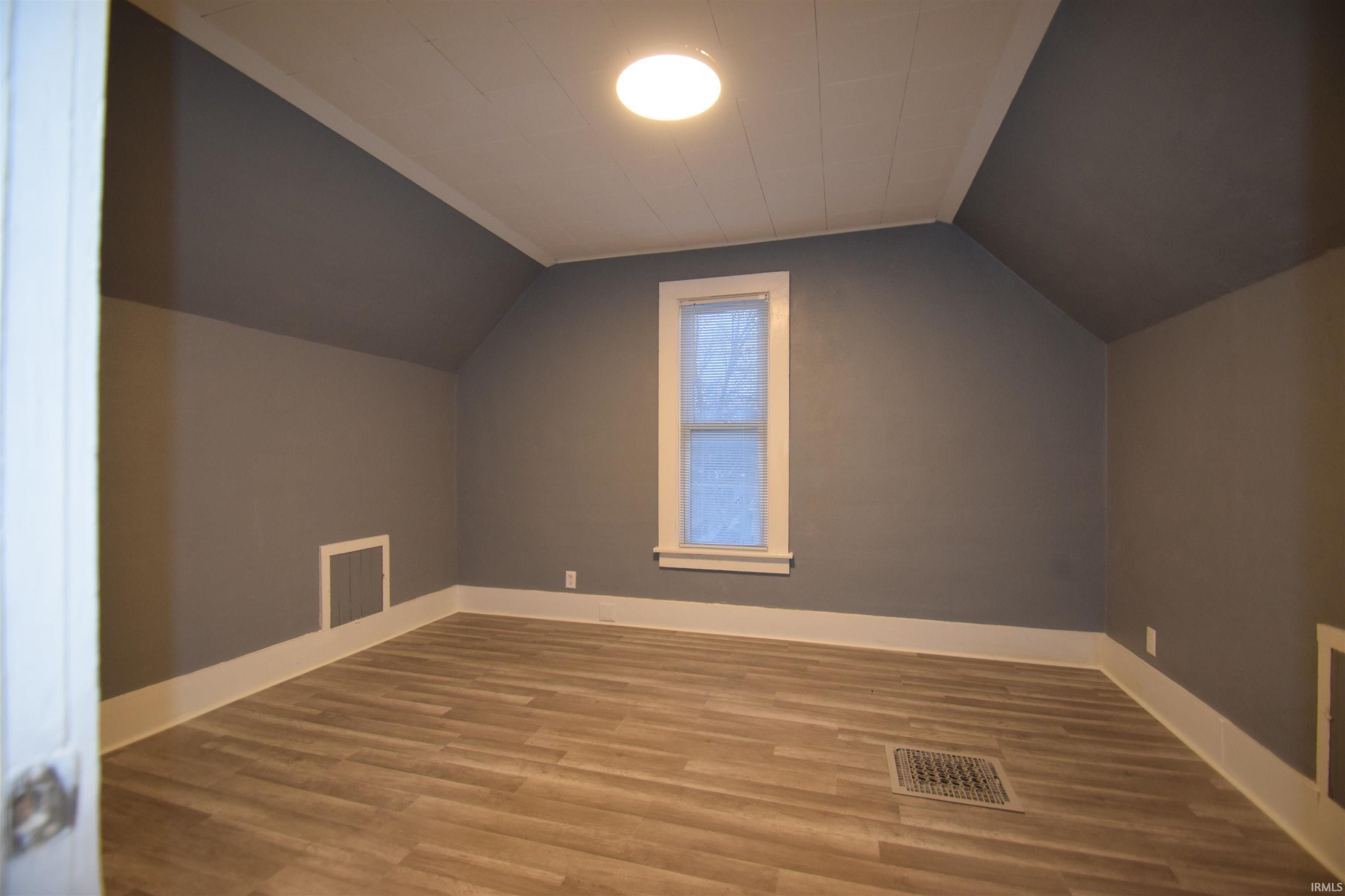Additional living space with wood finished floors and baseboards