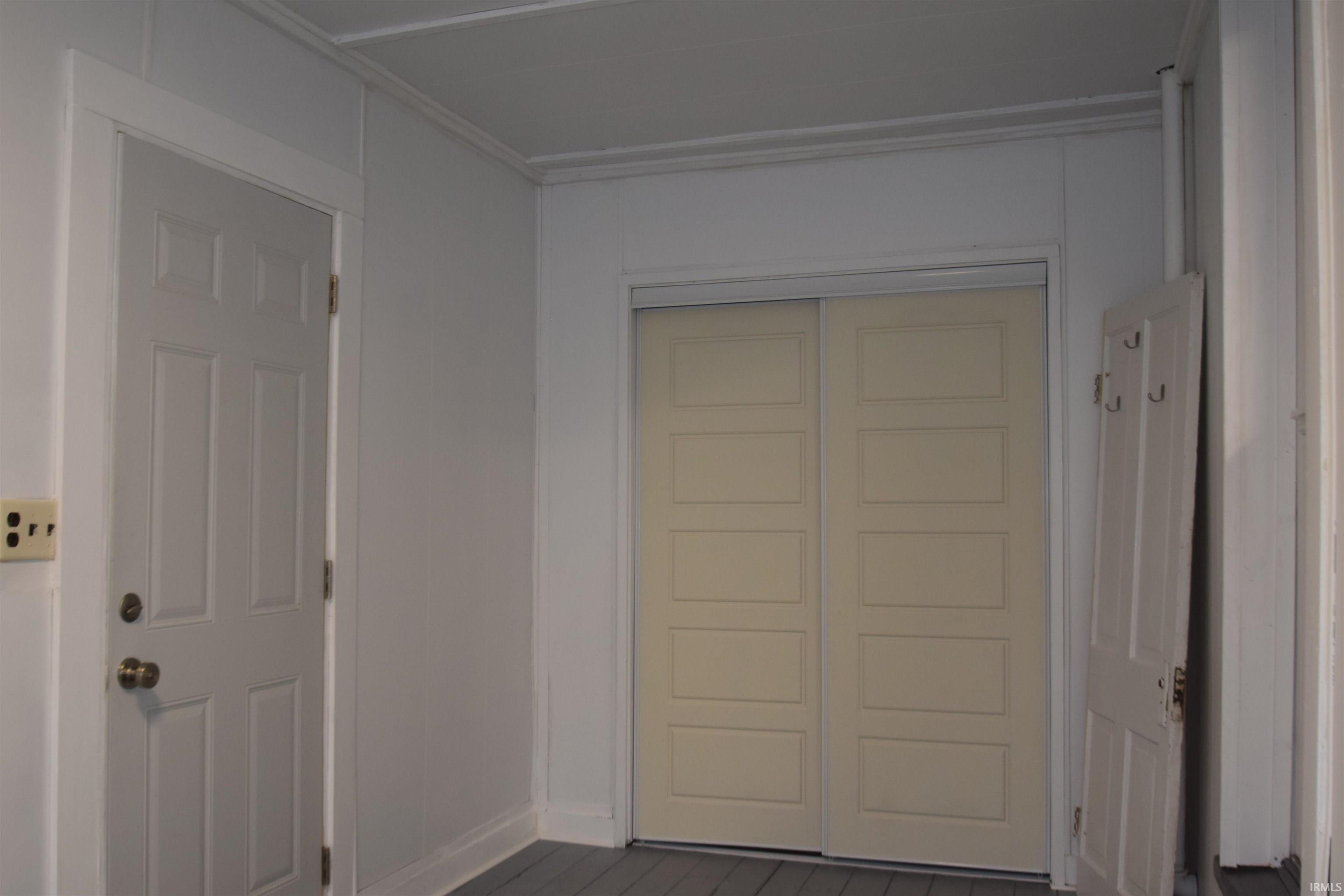 Doorway to outside with baseboards and wood finished floors