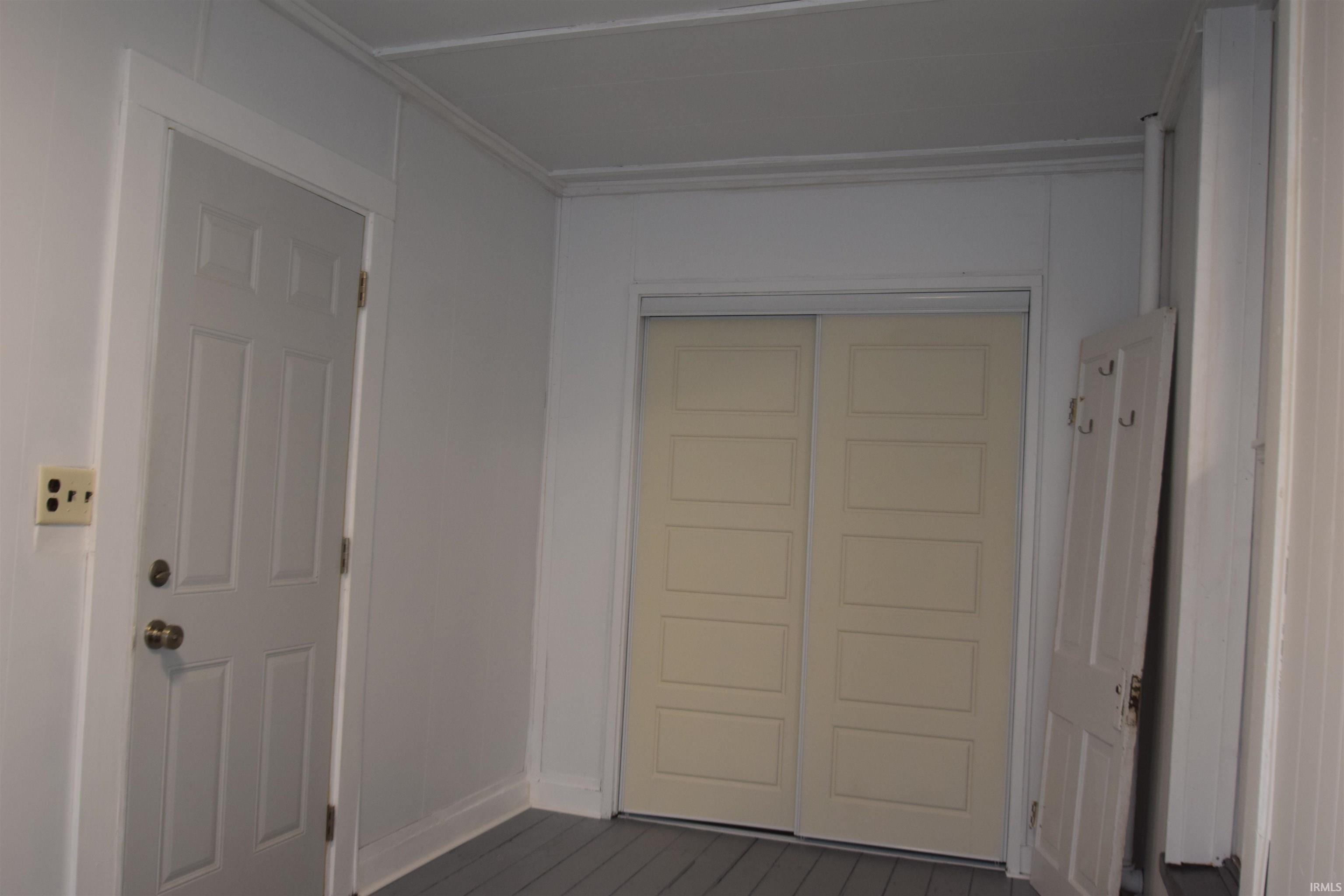 Hallway featuring dark wood-style floors and baseboards