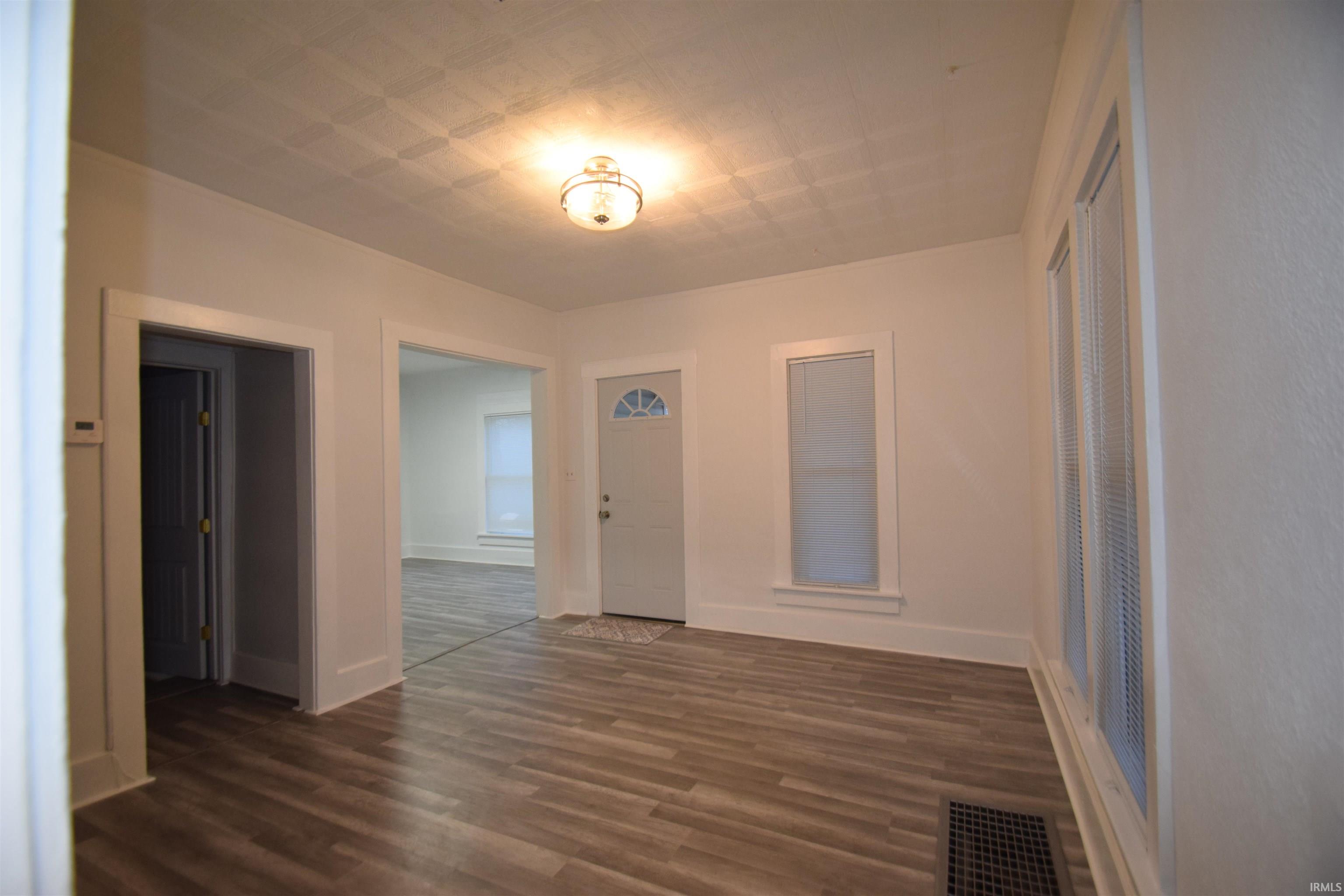 Unfurnished room featuring dark wood finished floors and an ornate ceiling