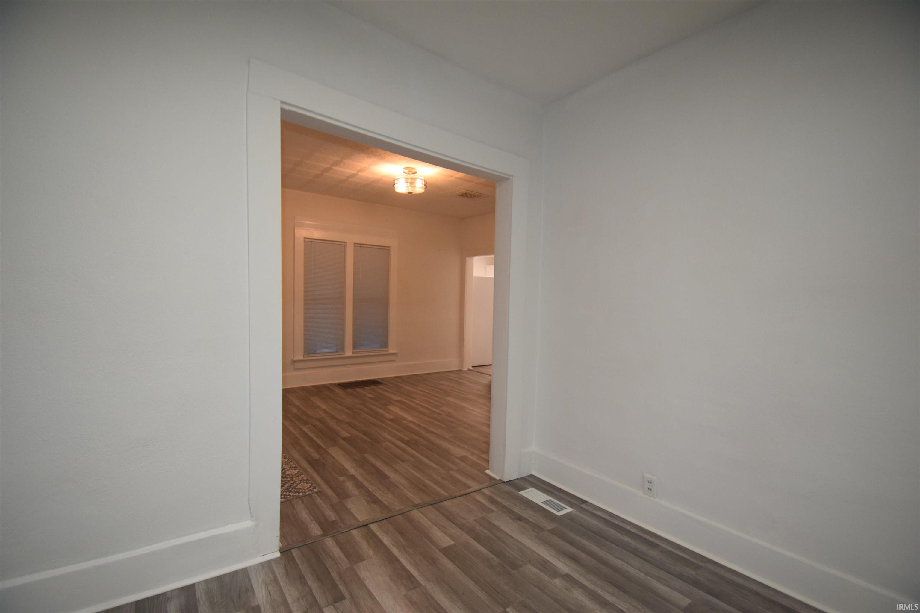 Unfurnished room with dark wood finished floors and baseboards