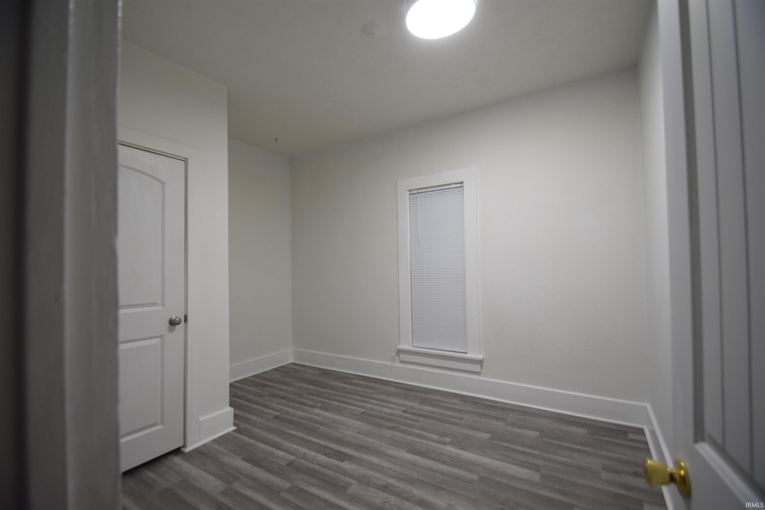 Empty room with baseboards and dark wood finished floors