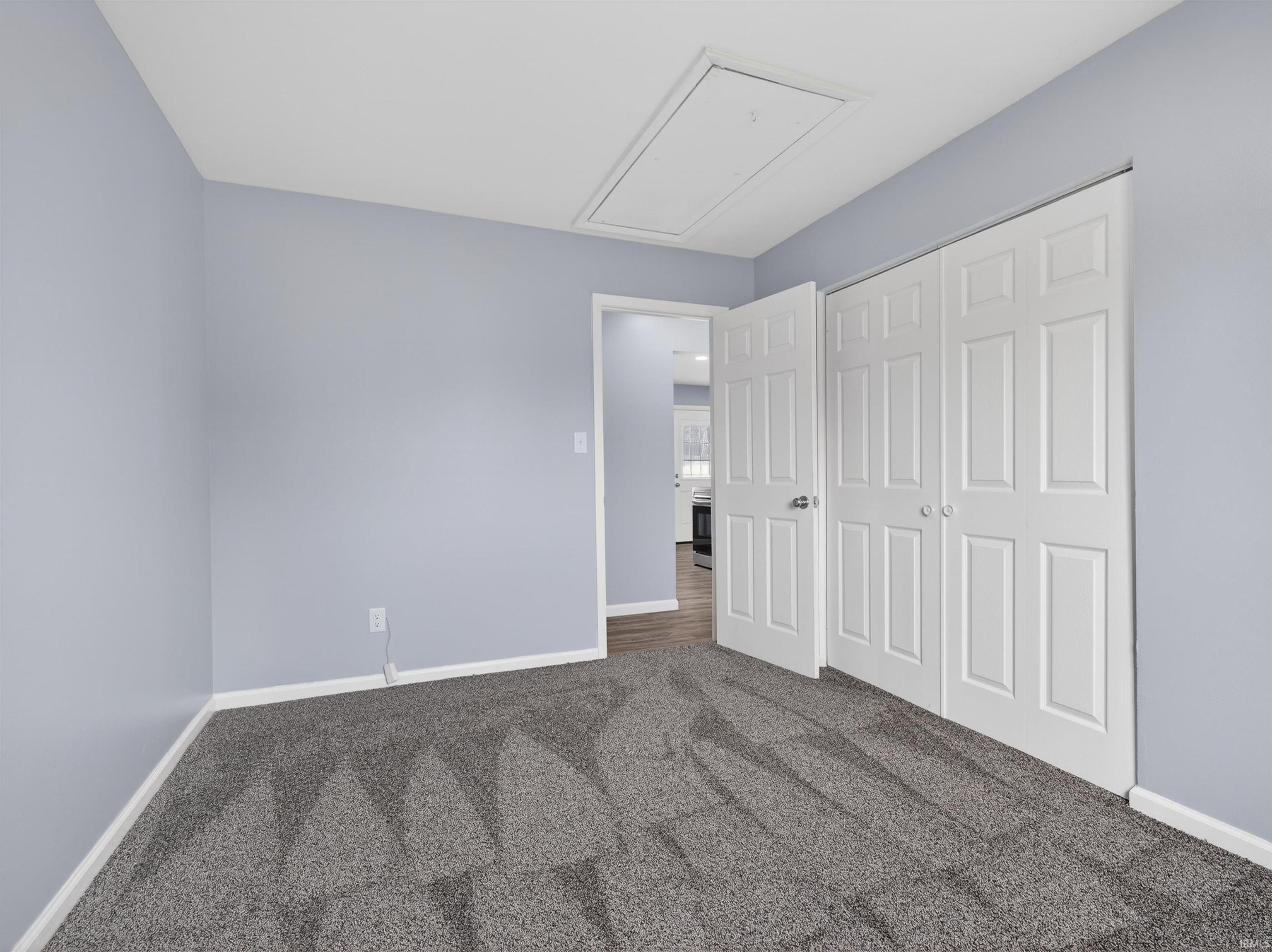 Unfurnished bedroom featuring dark colored carpet and a closet