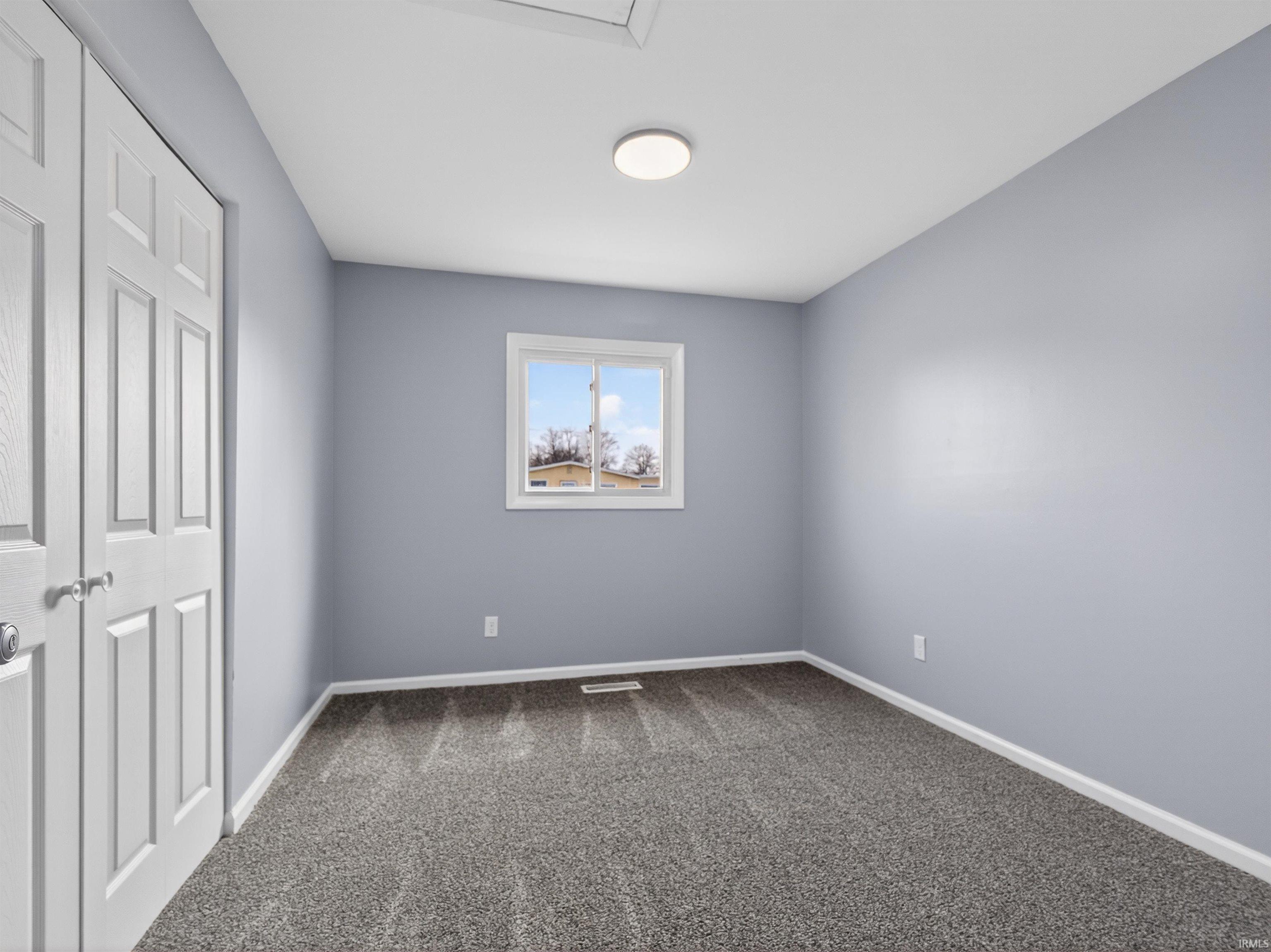 Unfurnished bedroom with a closet and dark colored carpet