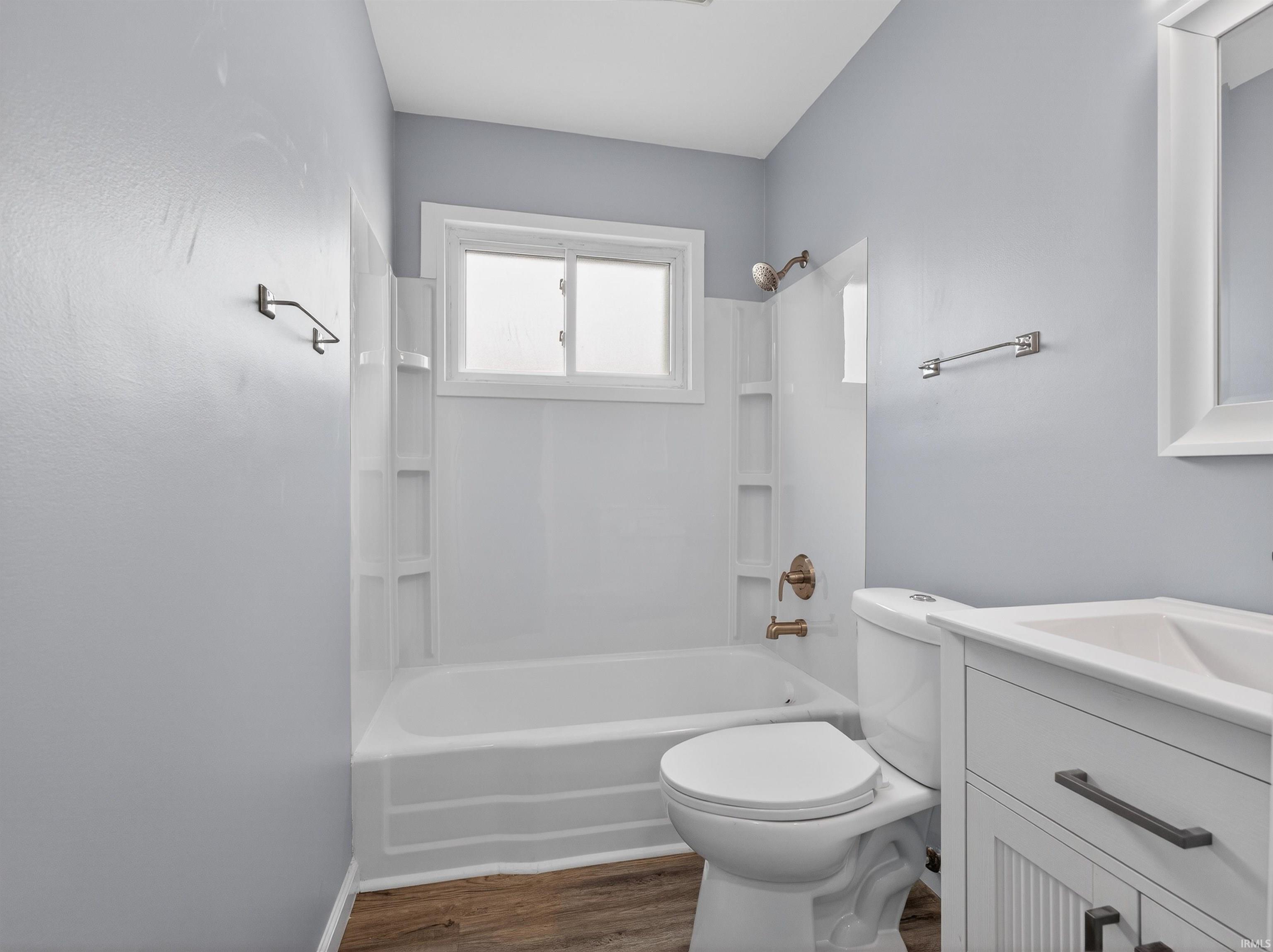 Full bath featuring vanity, shower / bathtub combination, and dark wood-style floors