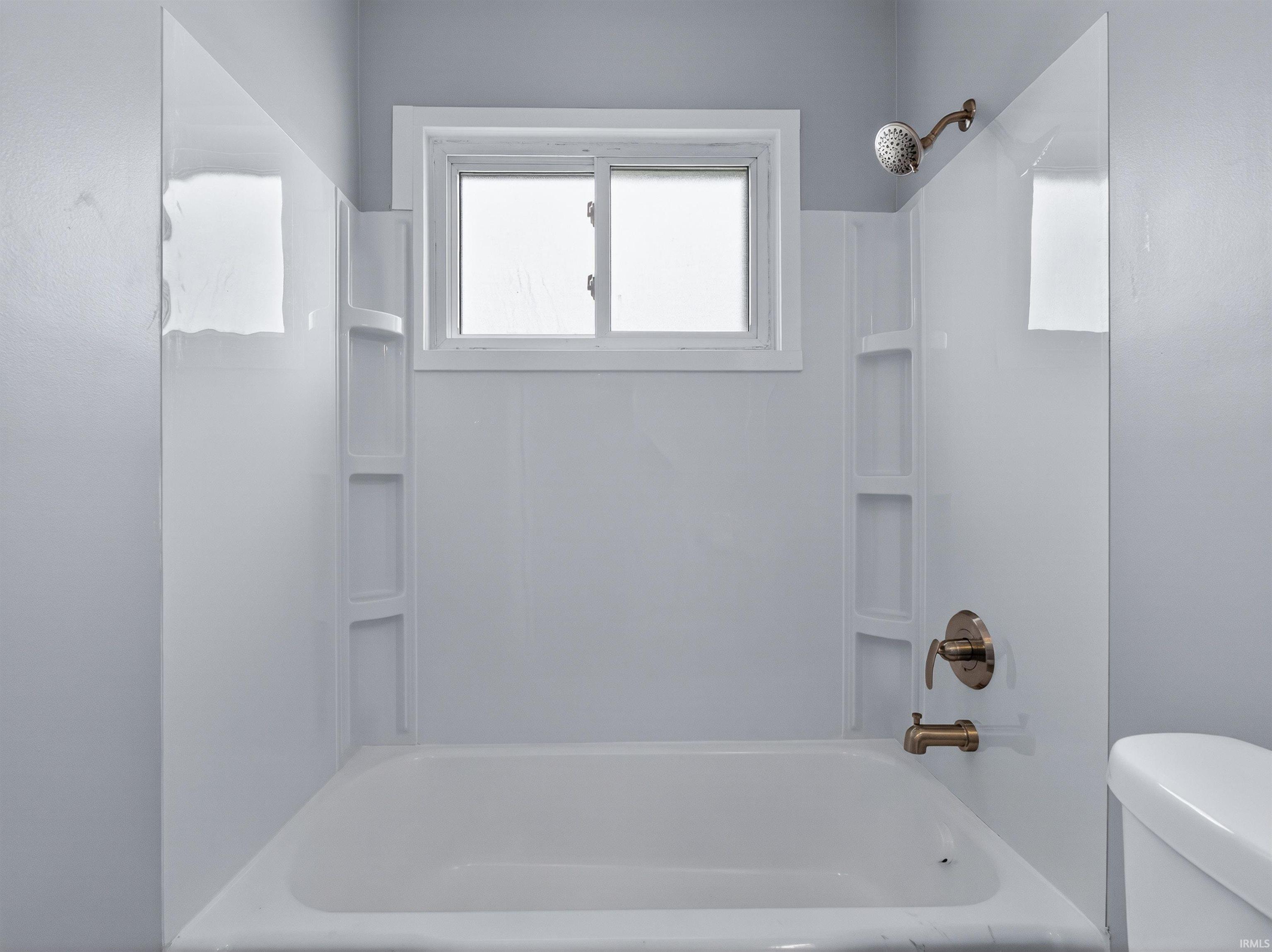 Bathroom with toilet and bathing tub / shower combination
