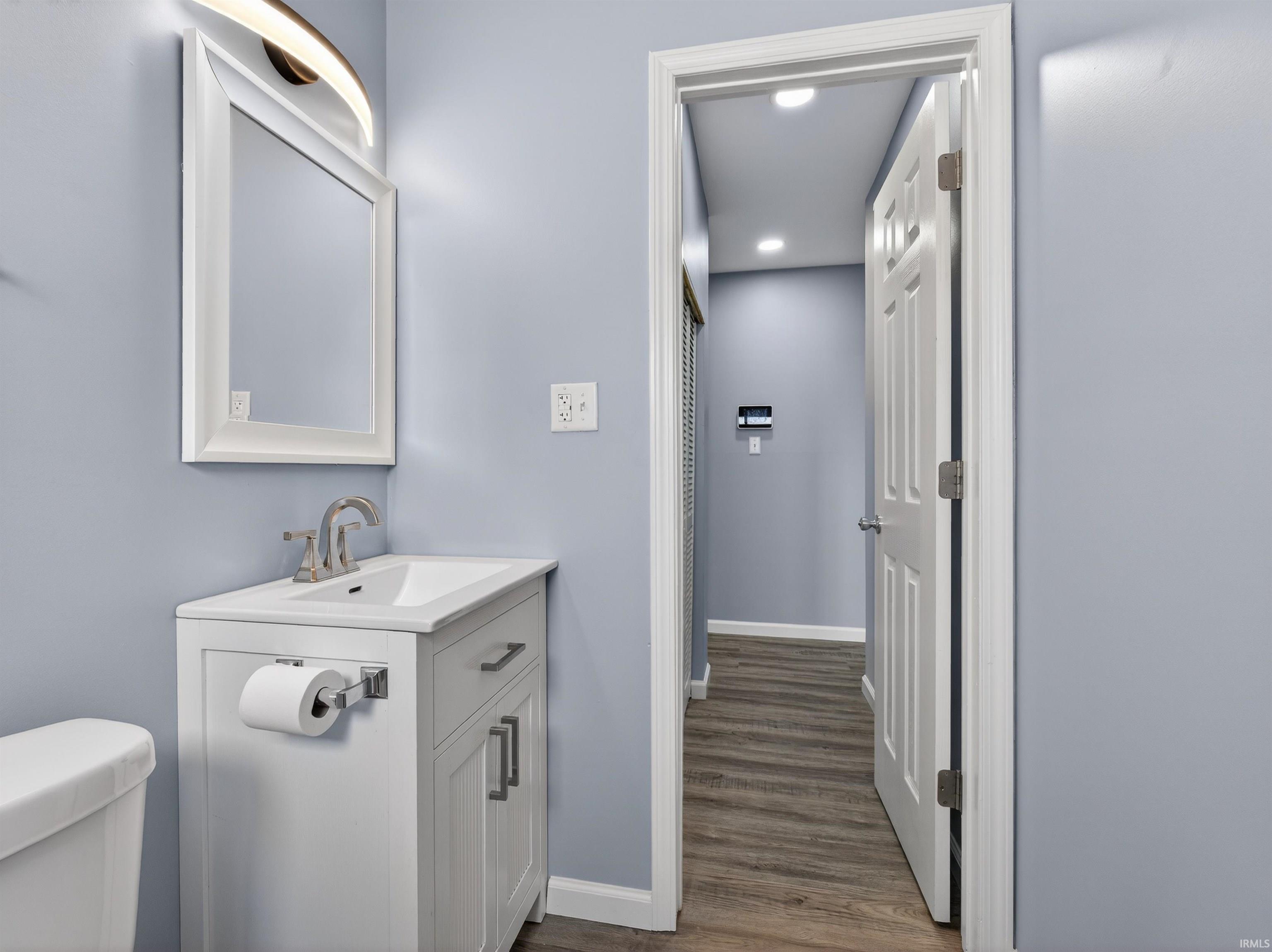 Half bath featuring vanity, recessed lighting, and dark wood finished floors