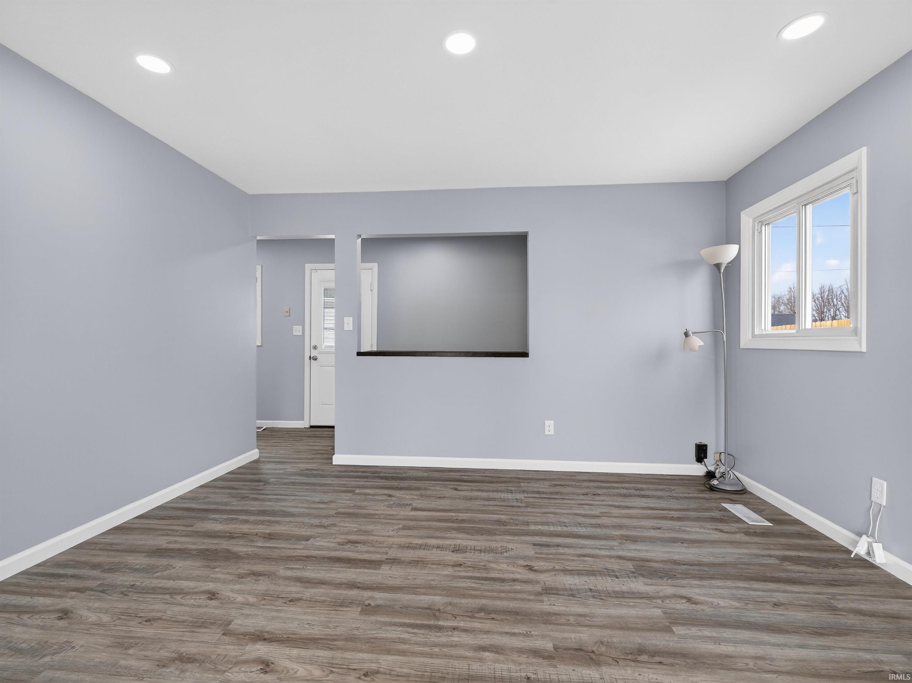 Empty room featuring dark wood finished floors and recessed lighting