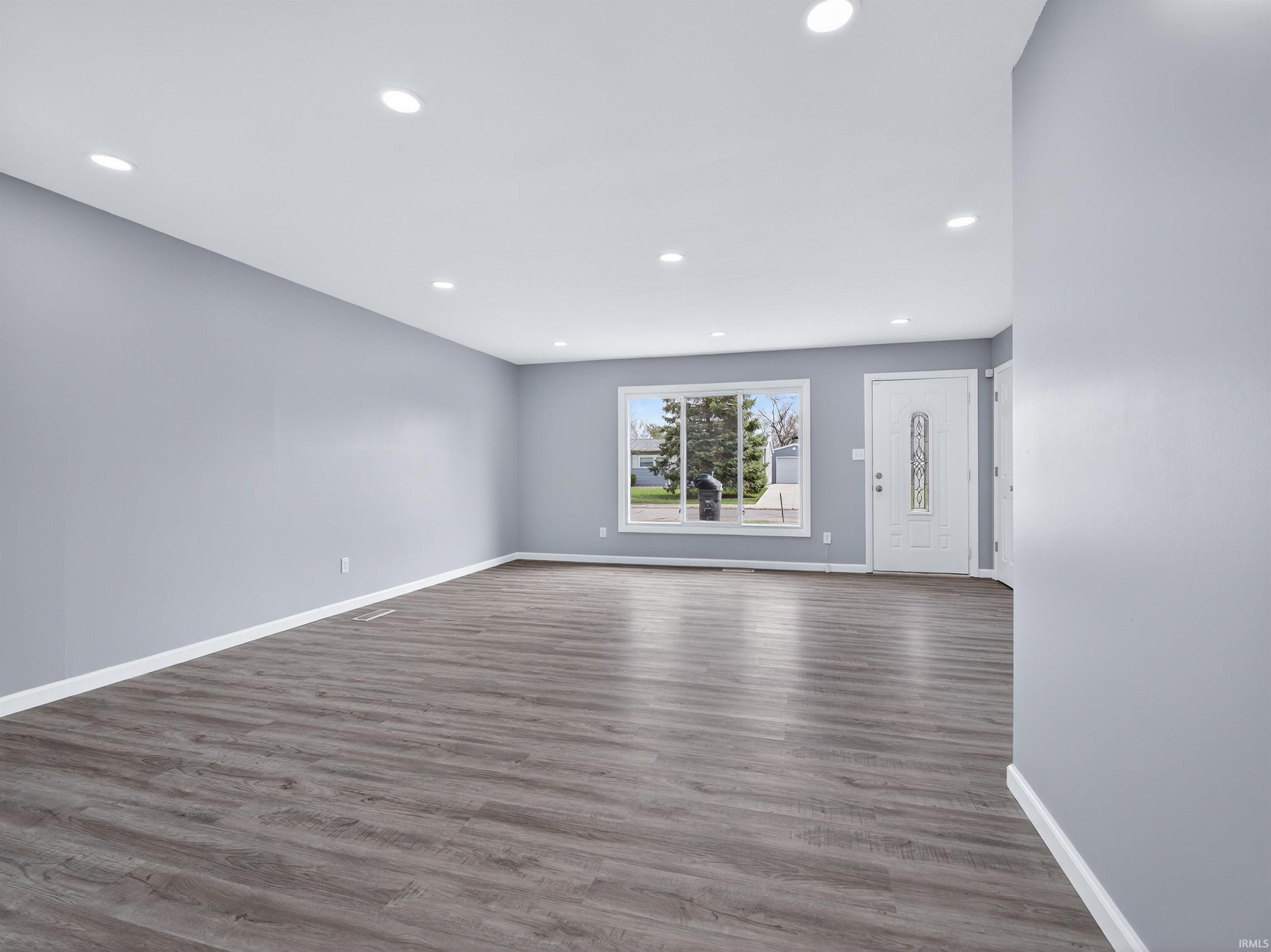 Unfurnished living room with dark wood finished floors and recessed lighting