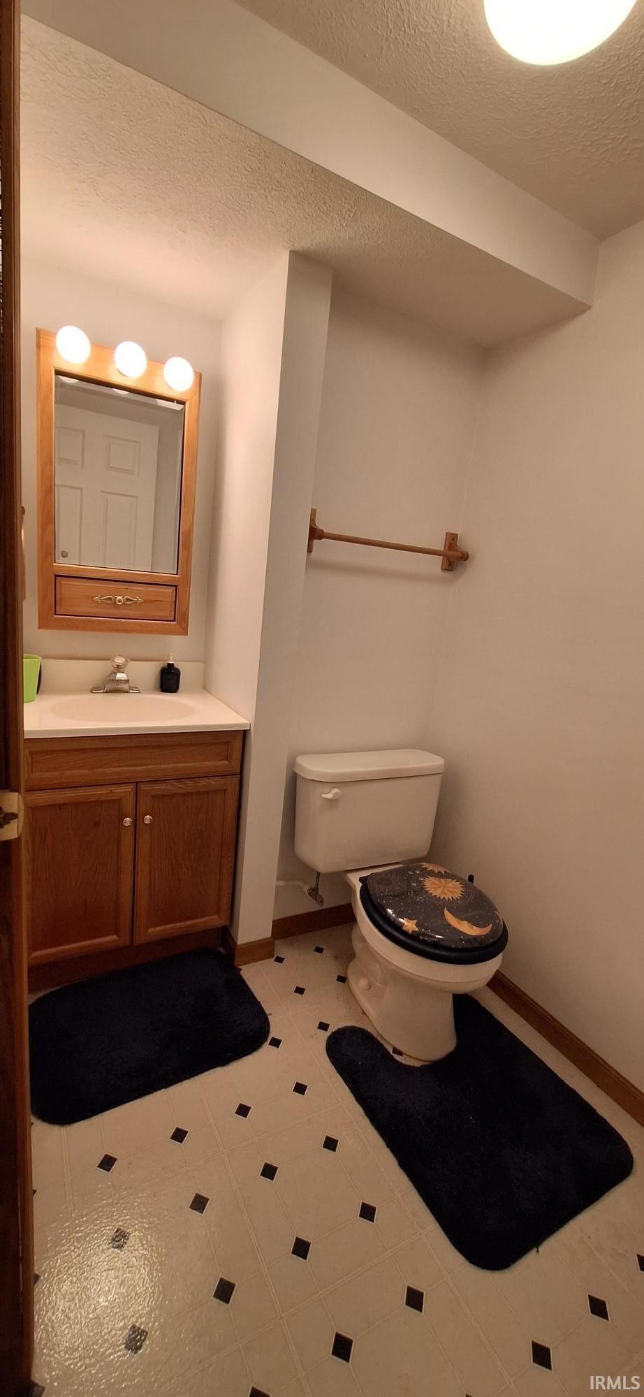 Bathroom with vanity, a textured ceiling, and light tile patterned floors