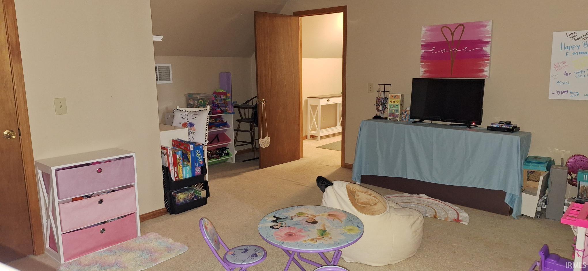 Playroom featuring lofted ceiling and light colored carpet