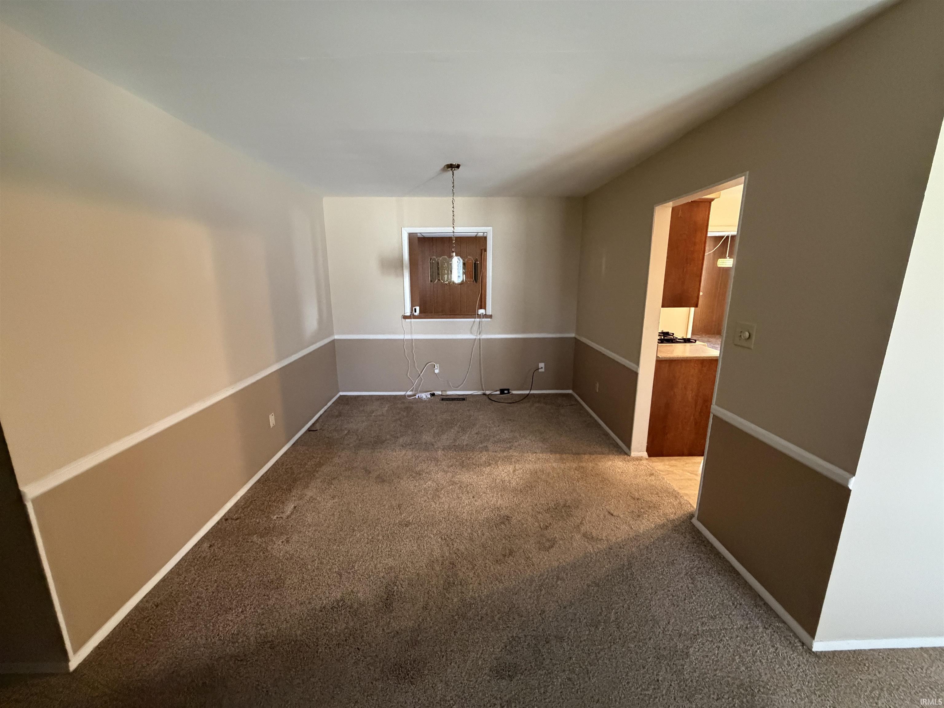 Unfurnished dining area featuring carpet floors and baseboards