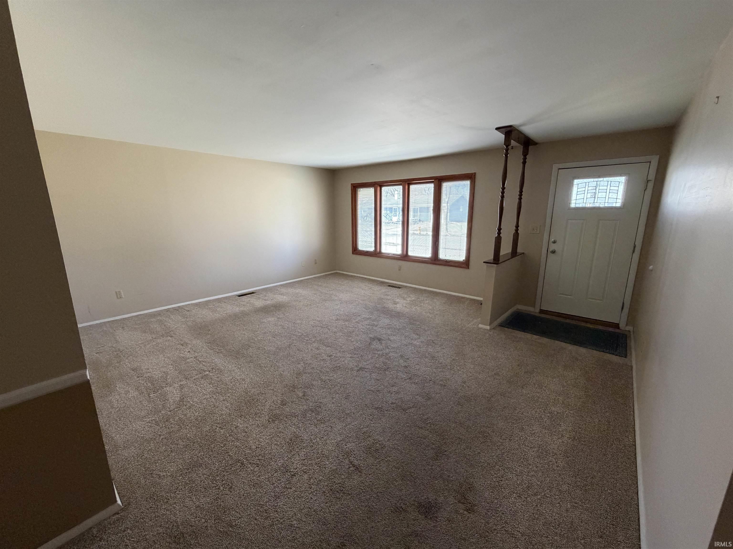 Foyer entrance featuring carpet flooring and baseboards
