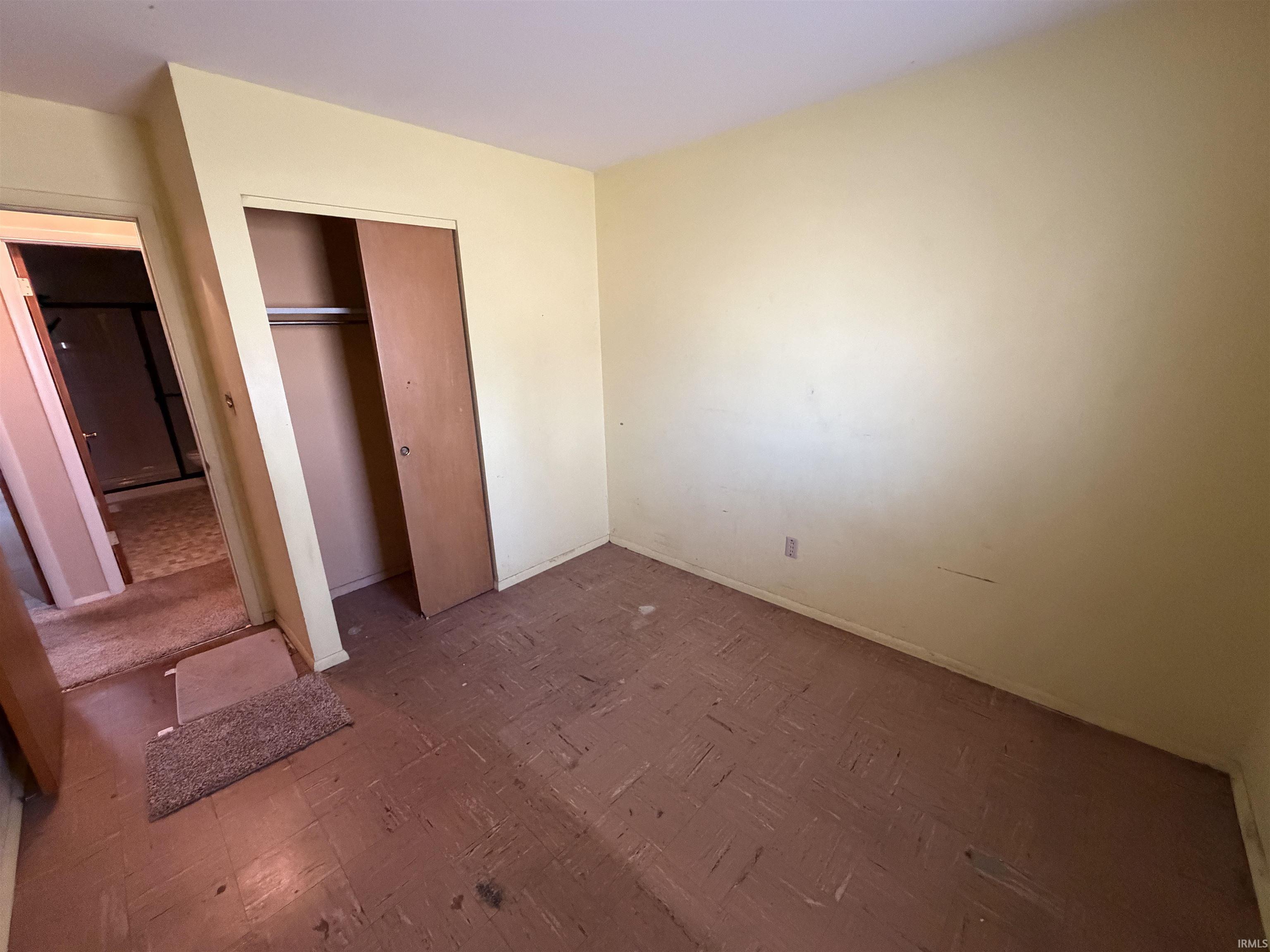 Unfurnished bedroom with a closet and baseboards