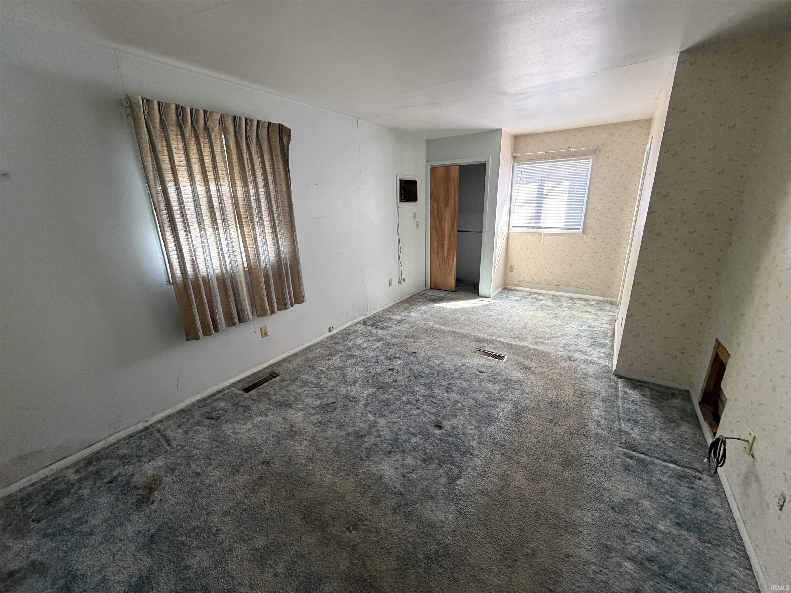 Unfurnished room with carpet flooring and wallpapered walls