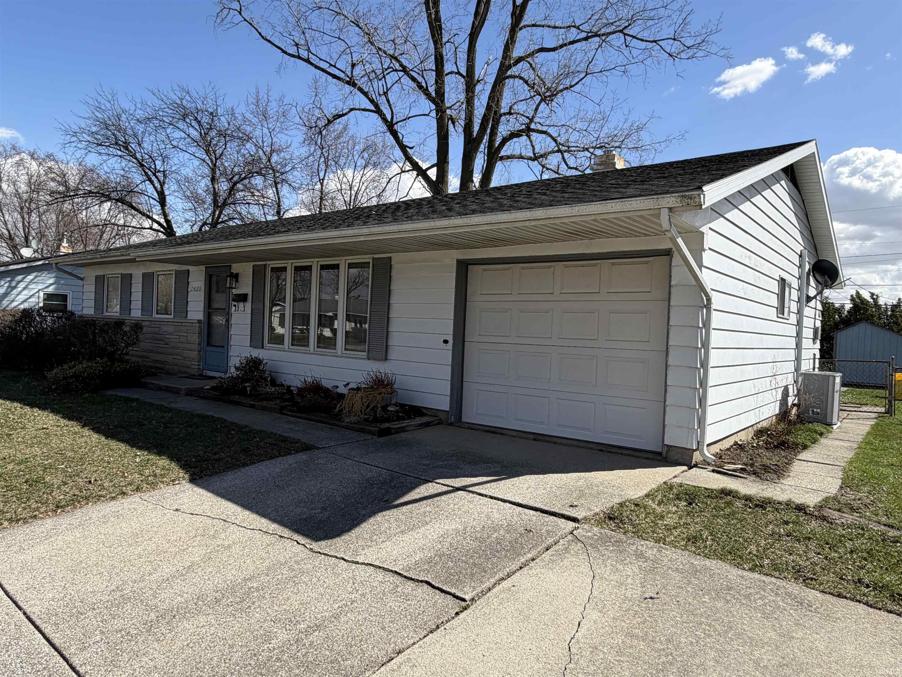 Single story home with concrete driveway, a garage, and a chimney