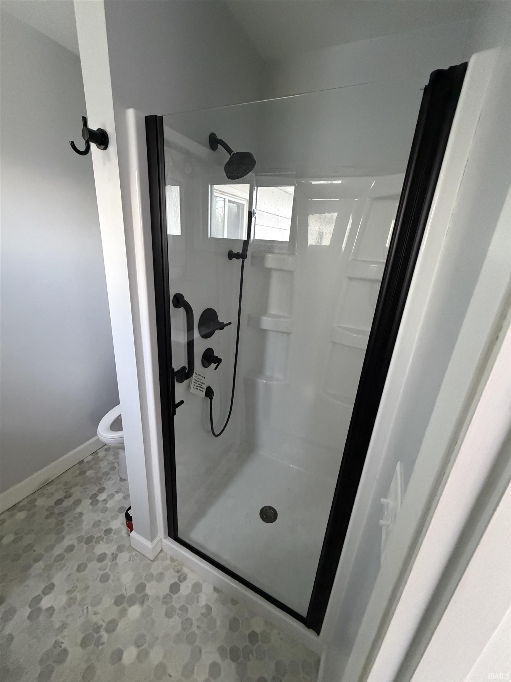 Full bath featuring a stall shower and toilet
