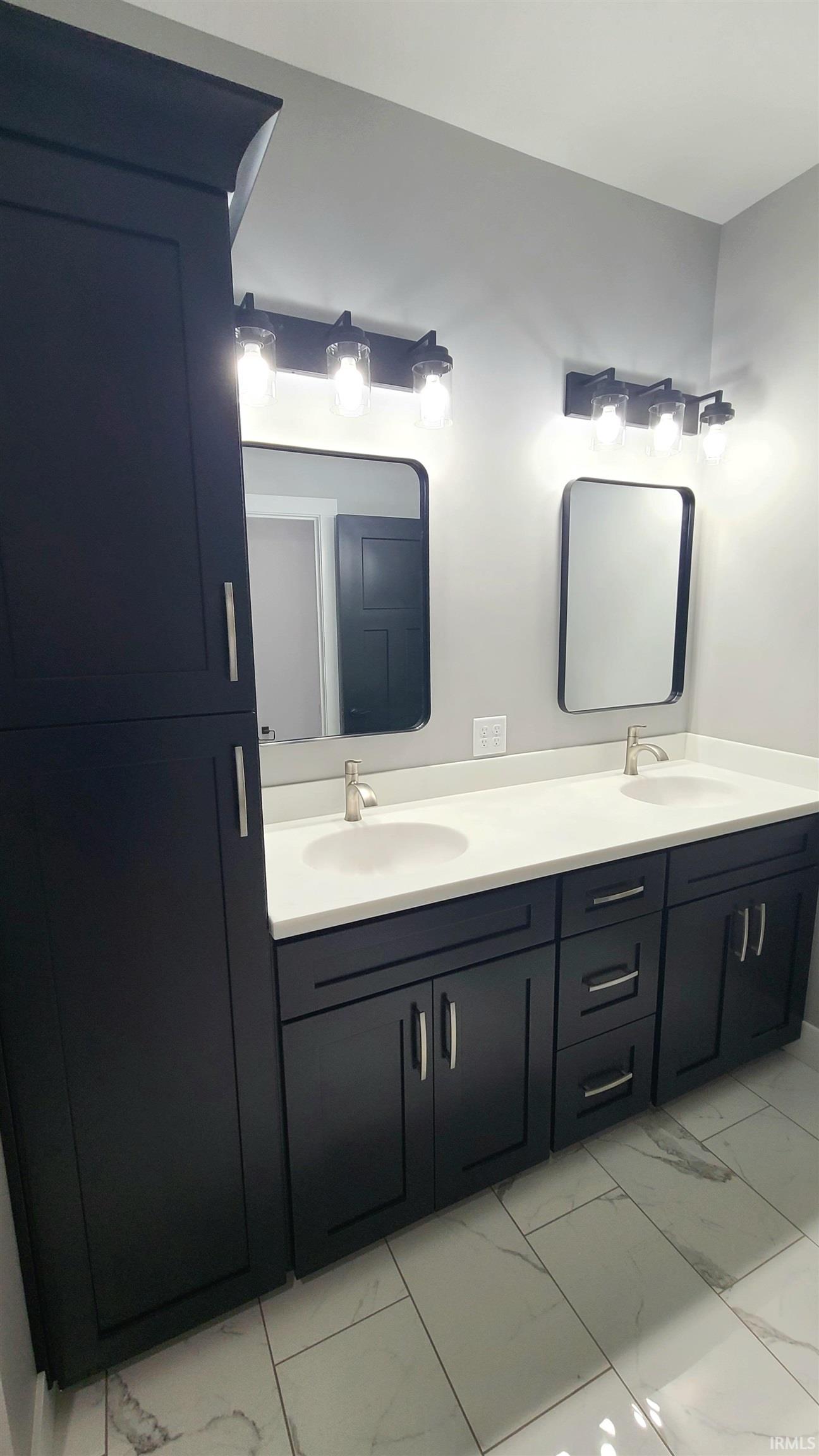 Full bath with double vanity and light marble finish floors