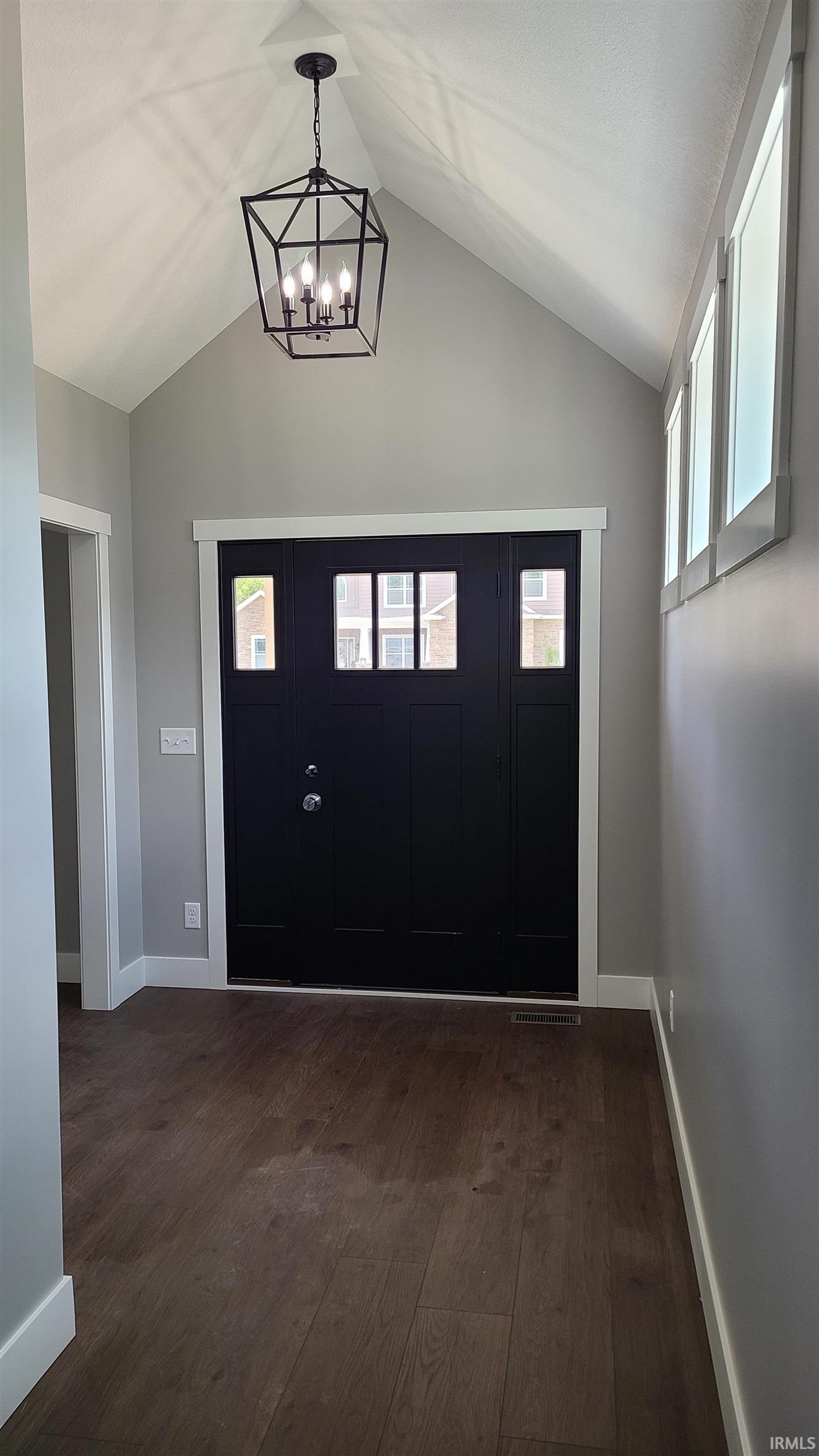 Entryway featuring dark wood finished floors, hanging lights, and healthy amount of natural light