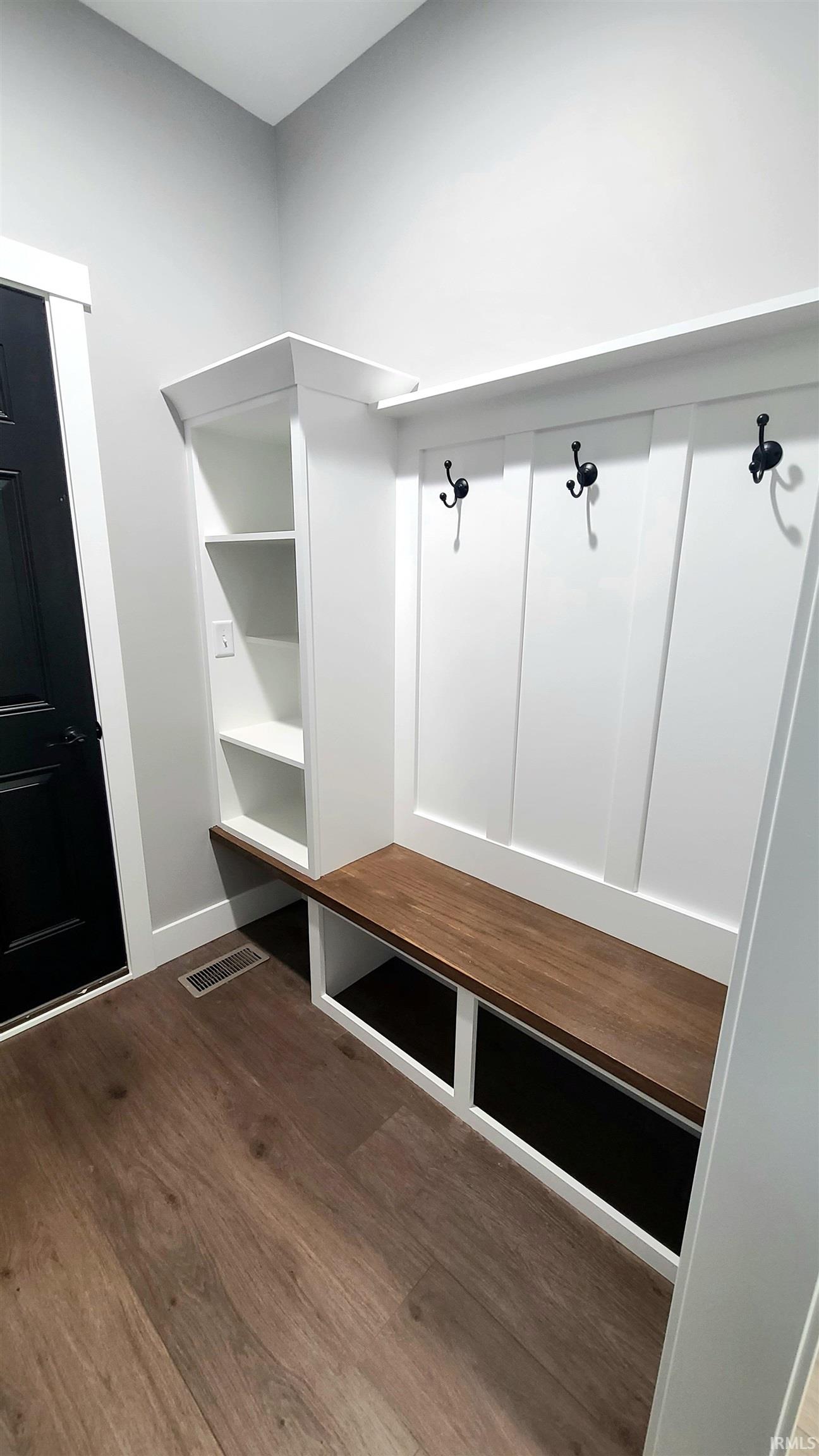 Mudroom with dark wood-style flooring and baseboards