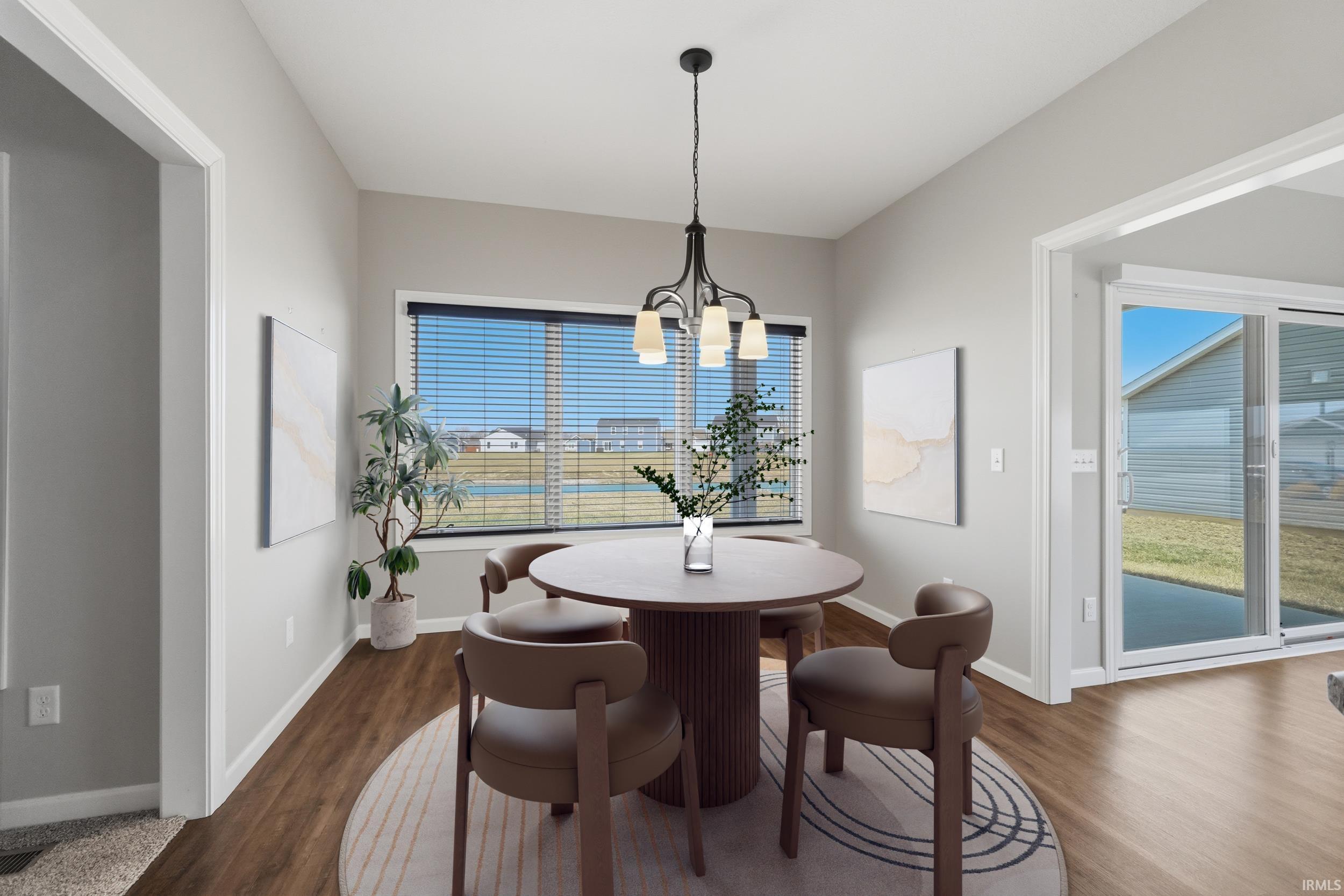Dining space with dark wood-style floors and suspended lighting
