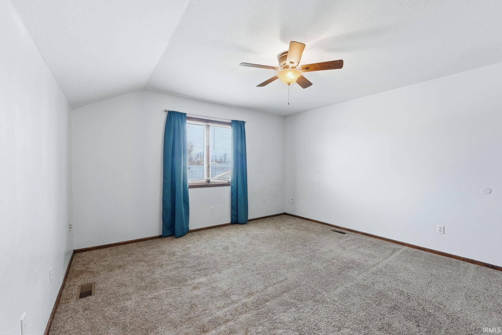 Additional living space with carpet, lofted ceiling, and ceiling fan