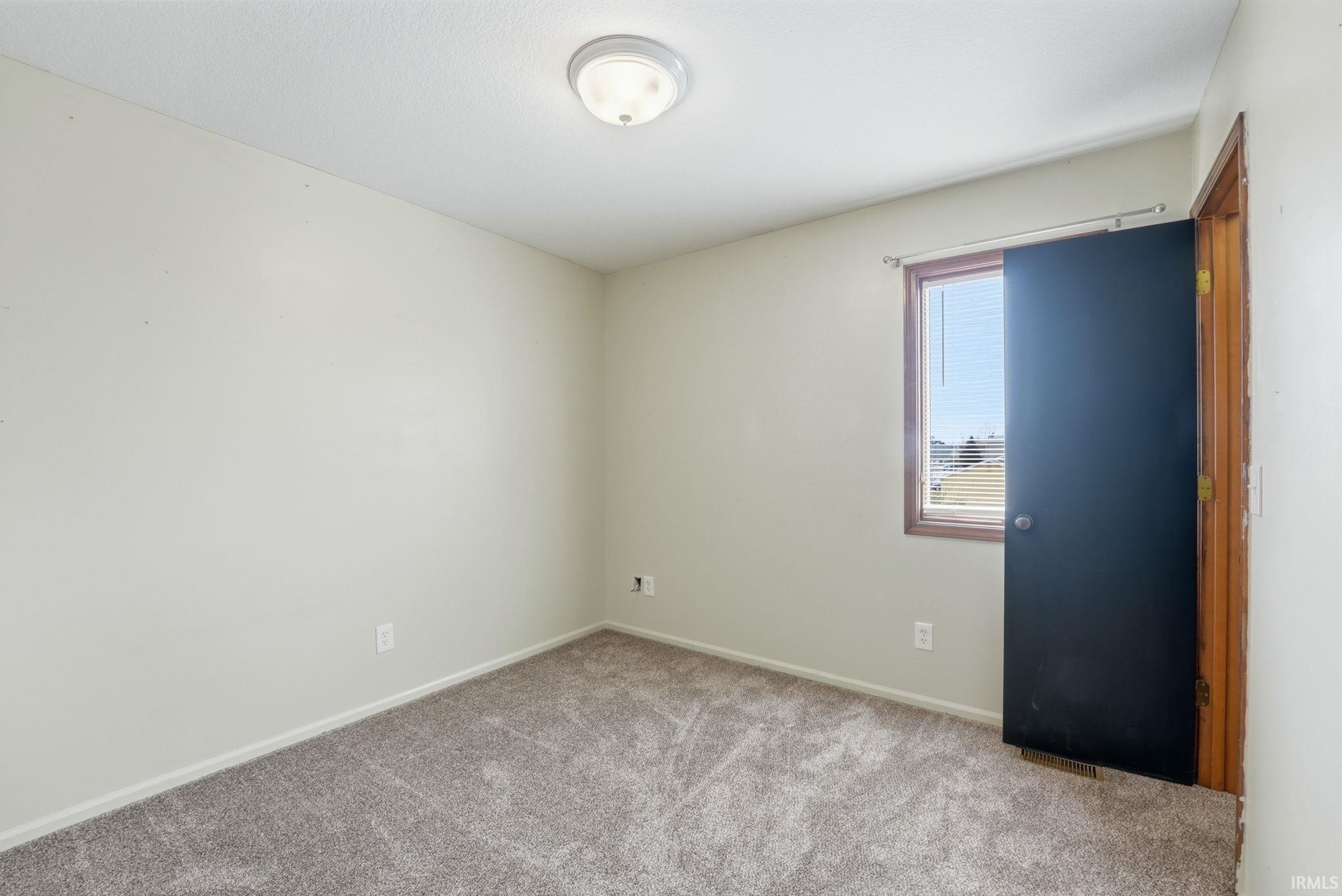 Carpeted empty room featuring baseboards