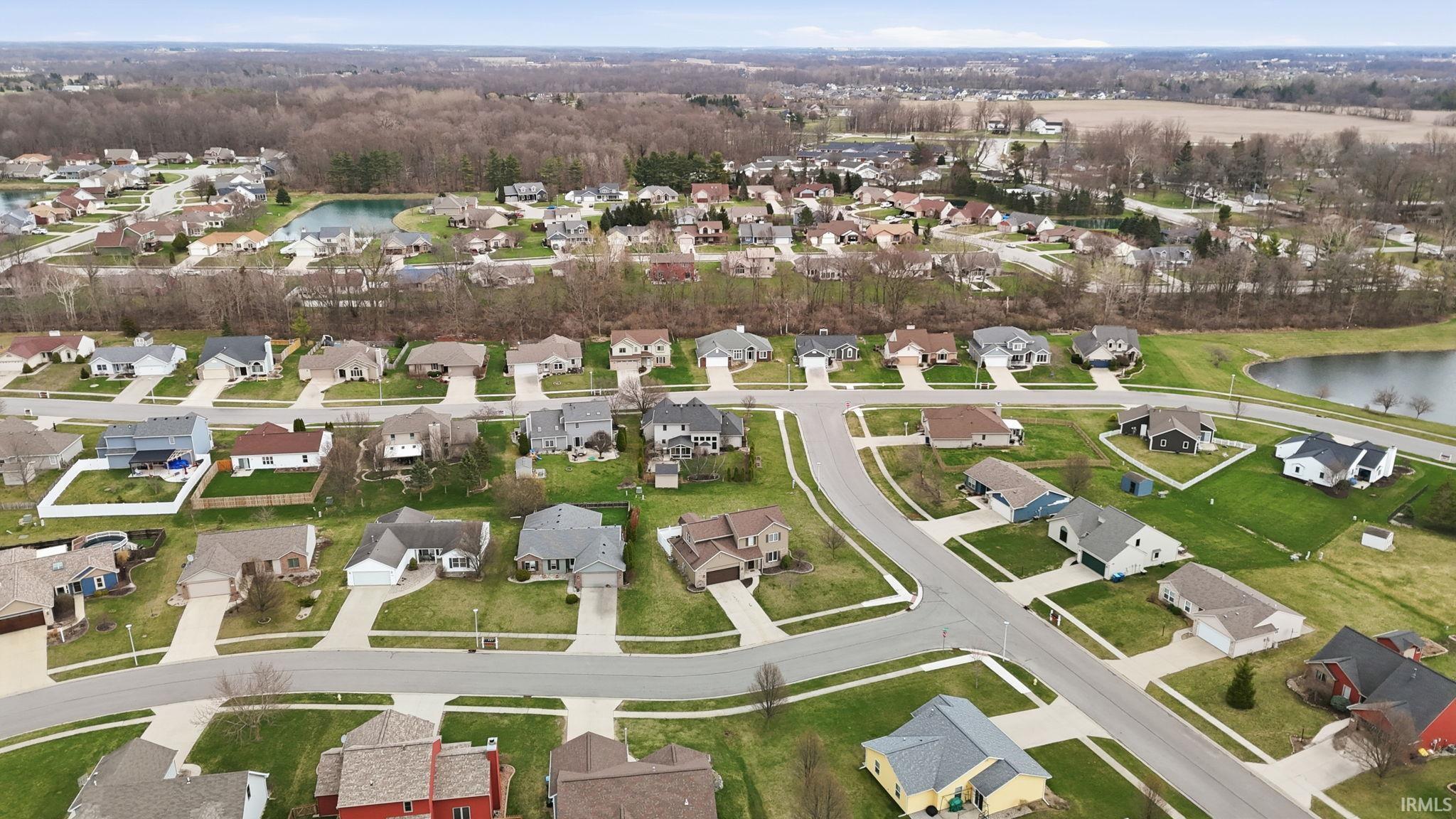 Aerial view of property's location with a nearby body of water and nearby suburban area