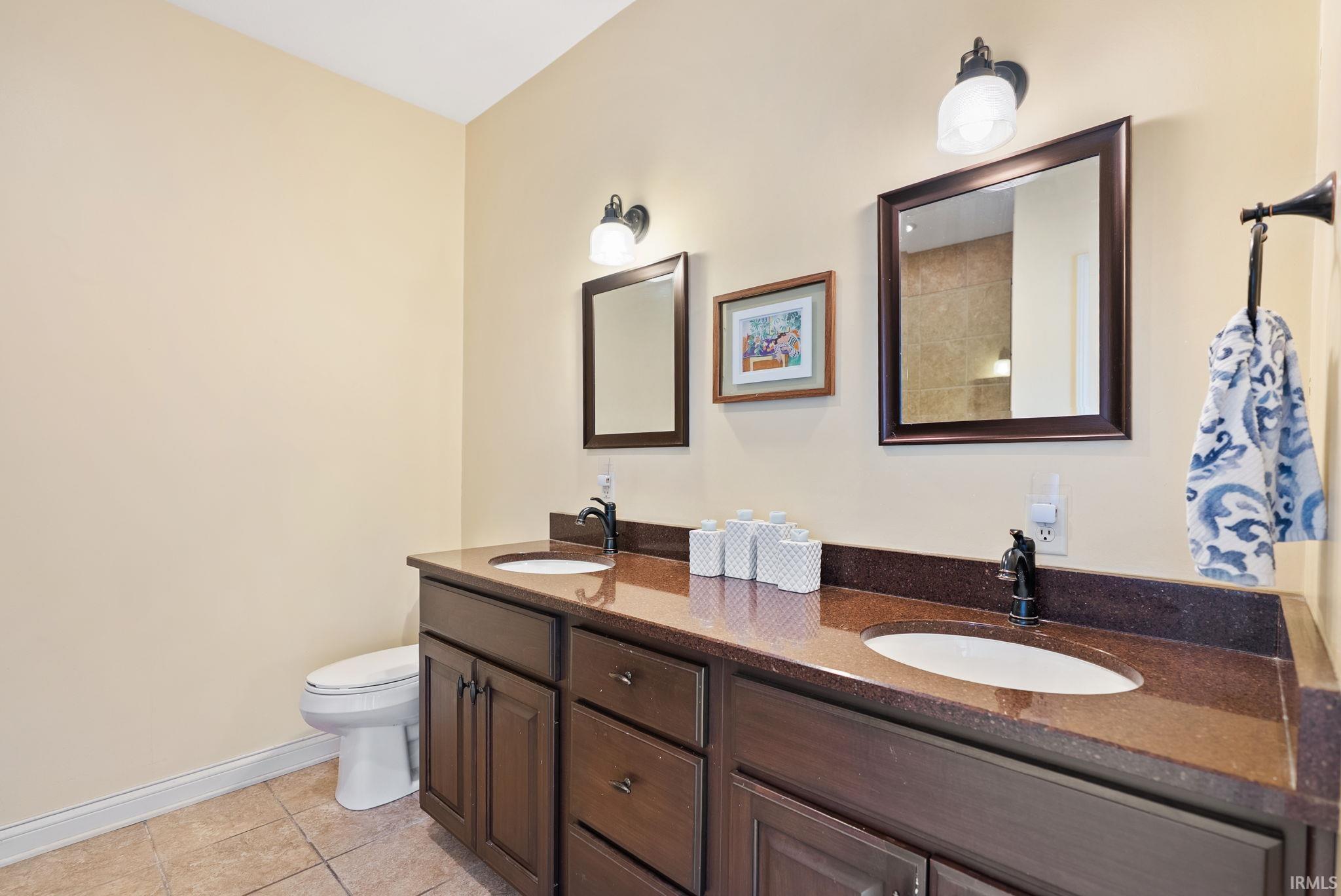 Bathroom featuring double vanity and light tile patterned floors