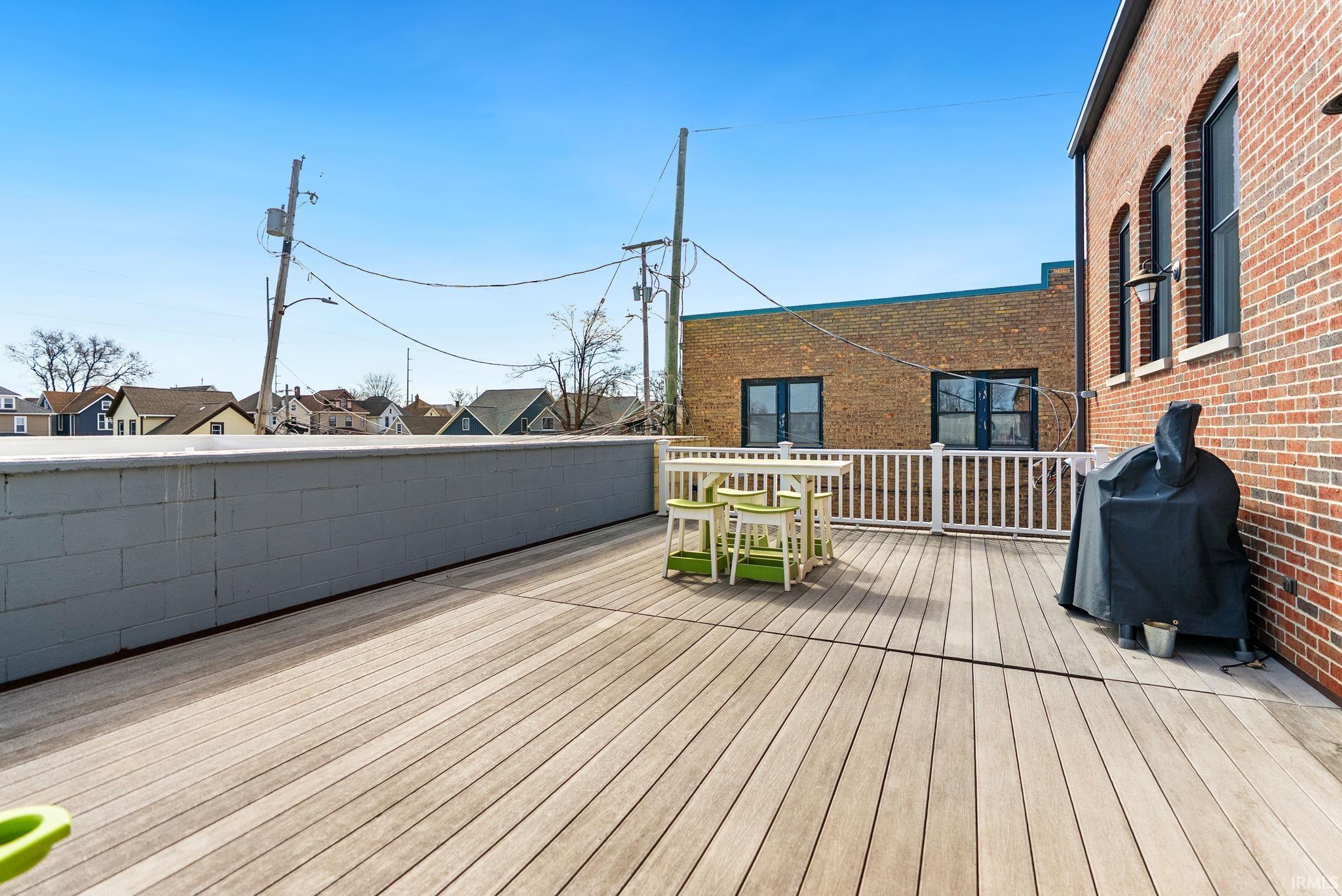 Wooden terrace with a residential view and a grill
