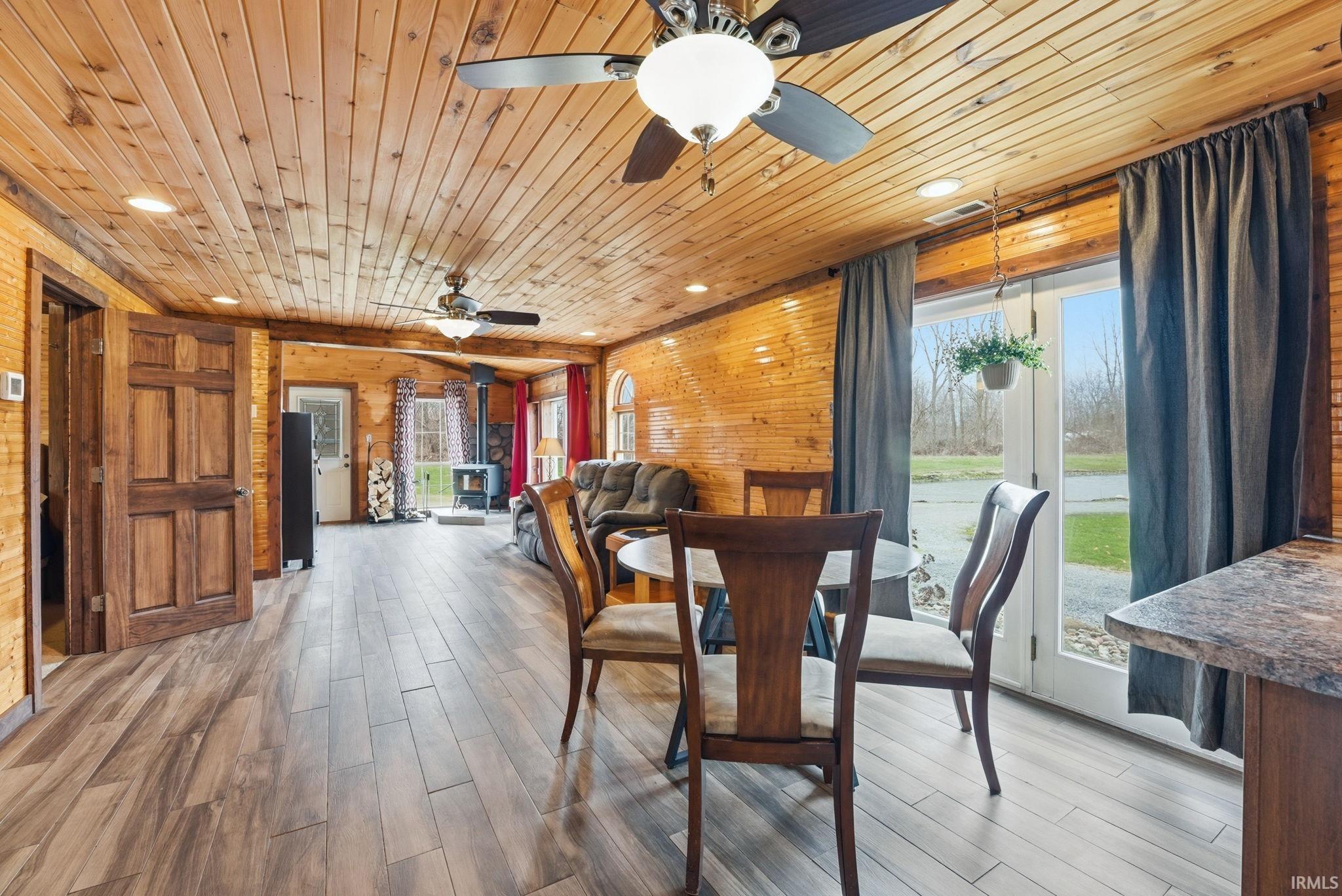 Dining area with recessed lighting, wood walls, light wood-style flooring, ceiling fan, and wooden ceiling