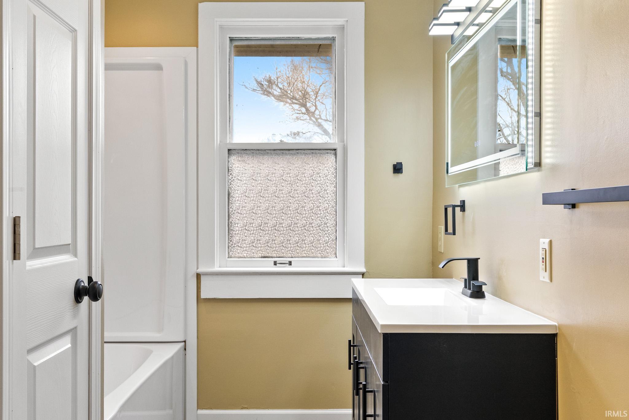 Full bath with vanity and a bathtub
