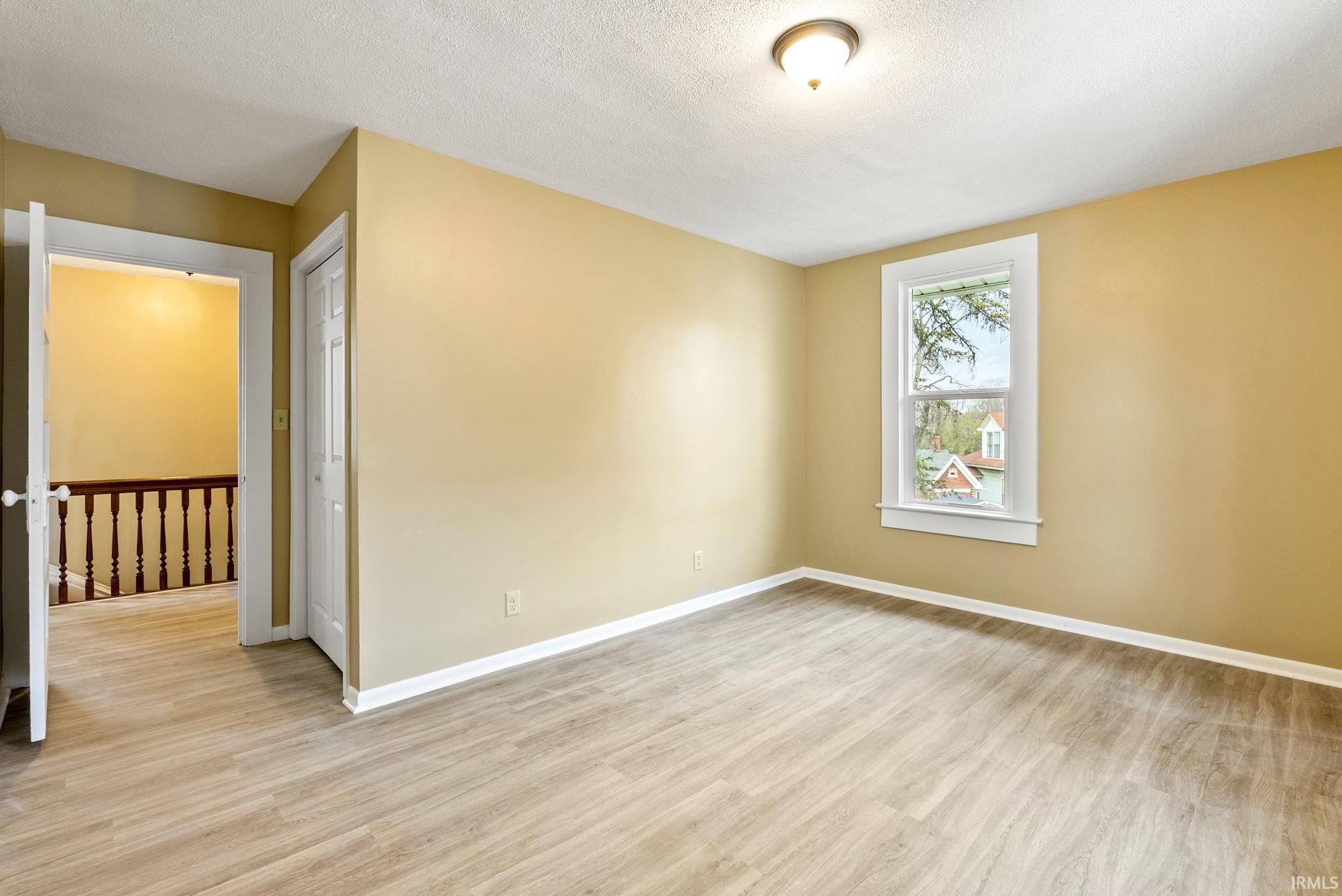 Spare room with light wood-style floors and a textured ceiling