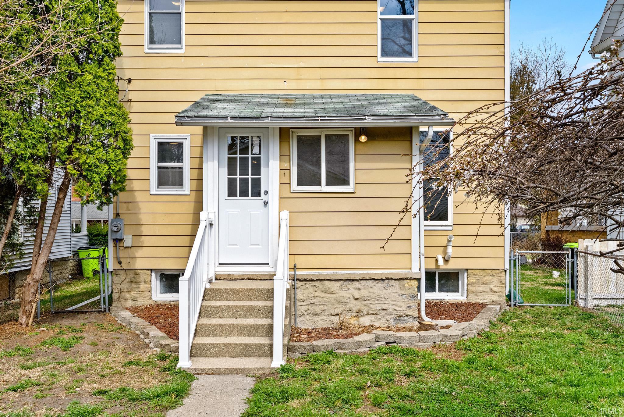 Doorway to property with a gate and a shingled roof
