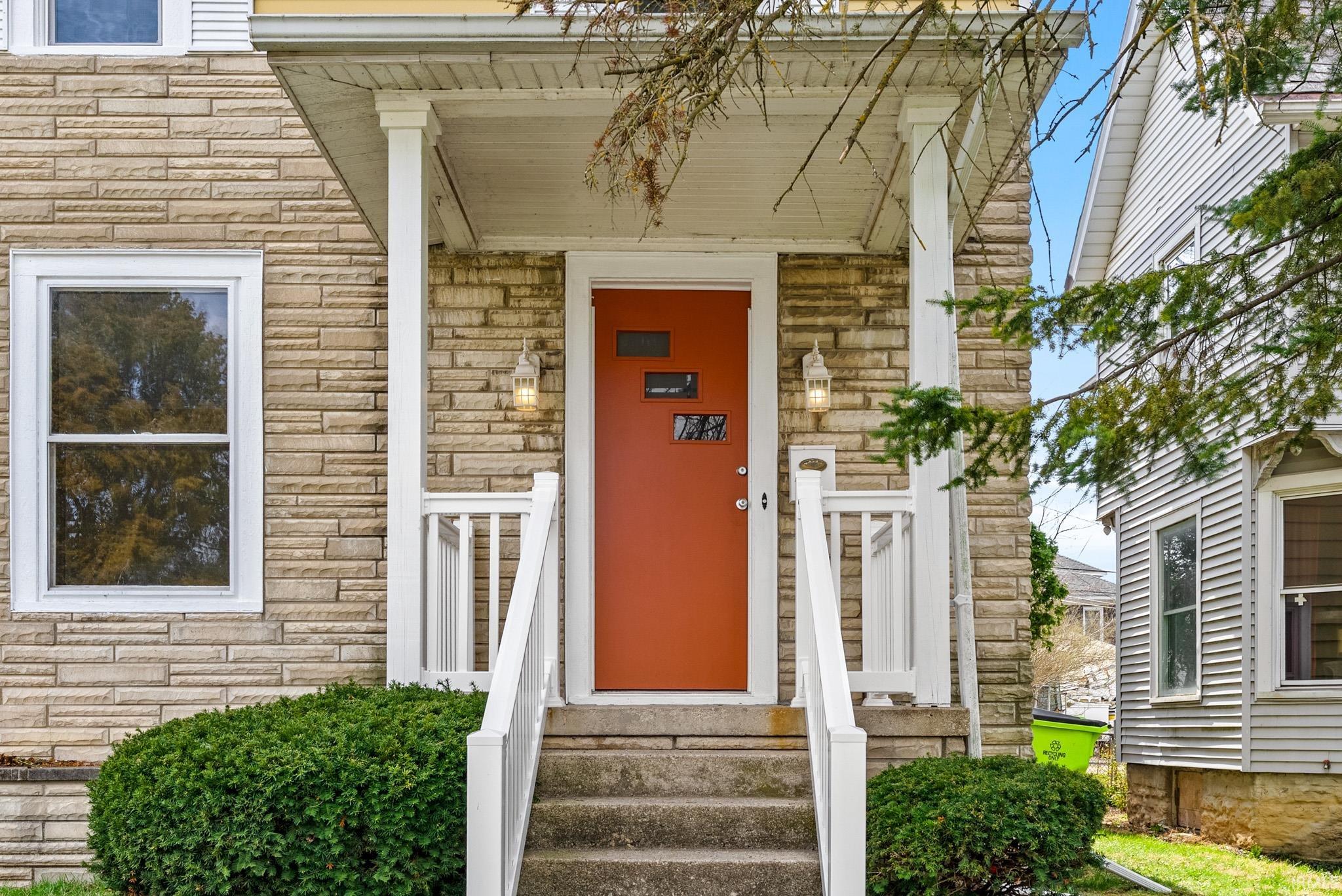 Entrance to property with stone siding and a porch