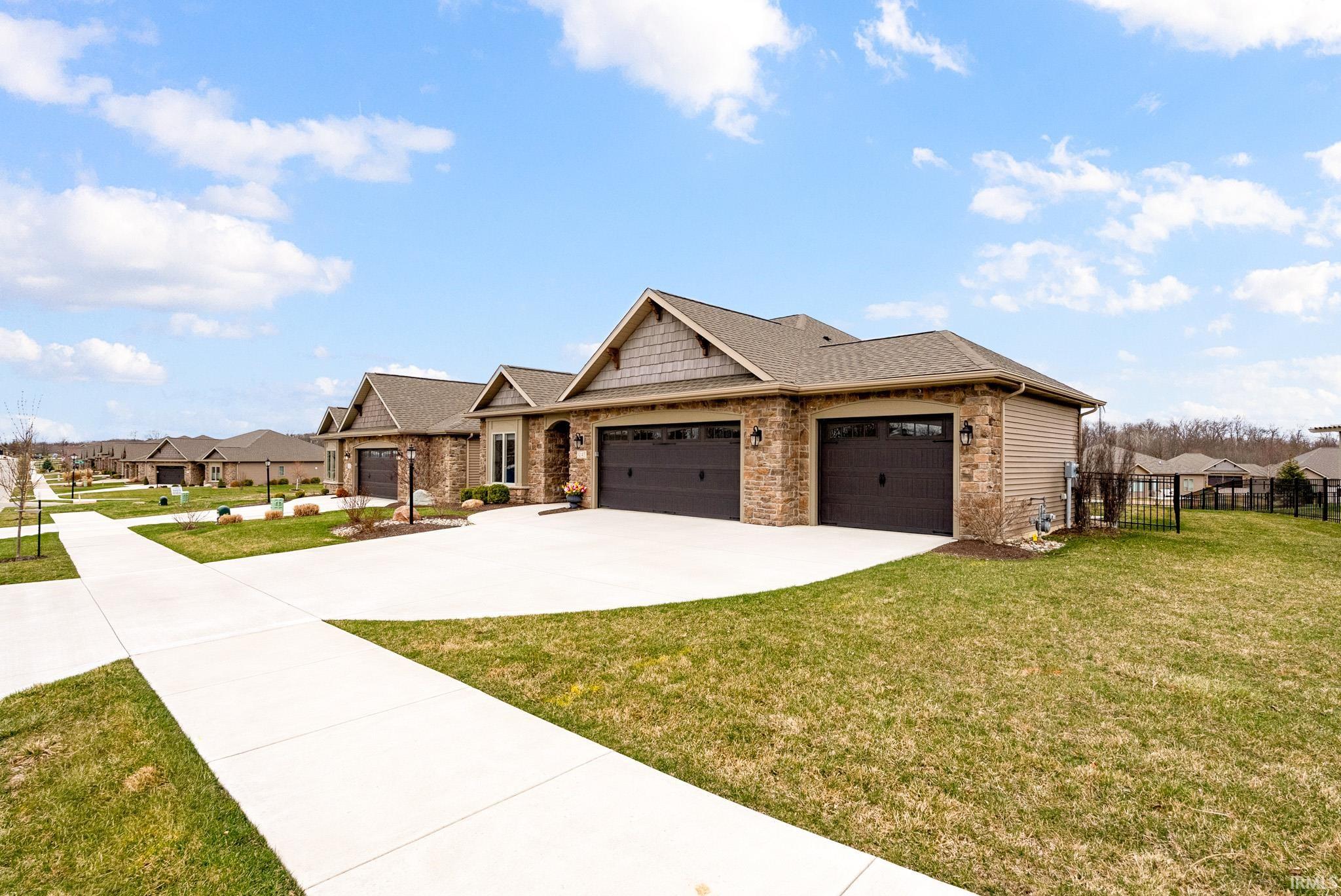 Craftsman-style house featuring stone siding, an attached garage, and a residential view