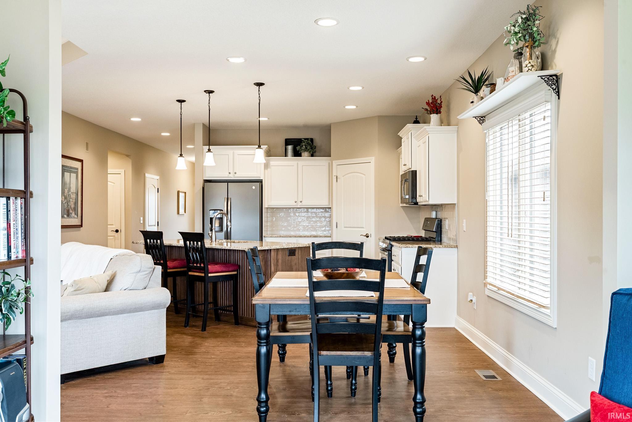 Dining area with healthy amount of natural light, dark wood finished floors, and recessed lighting