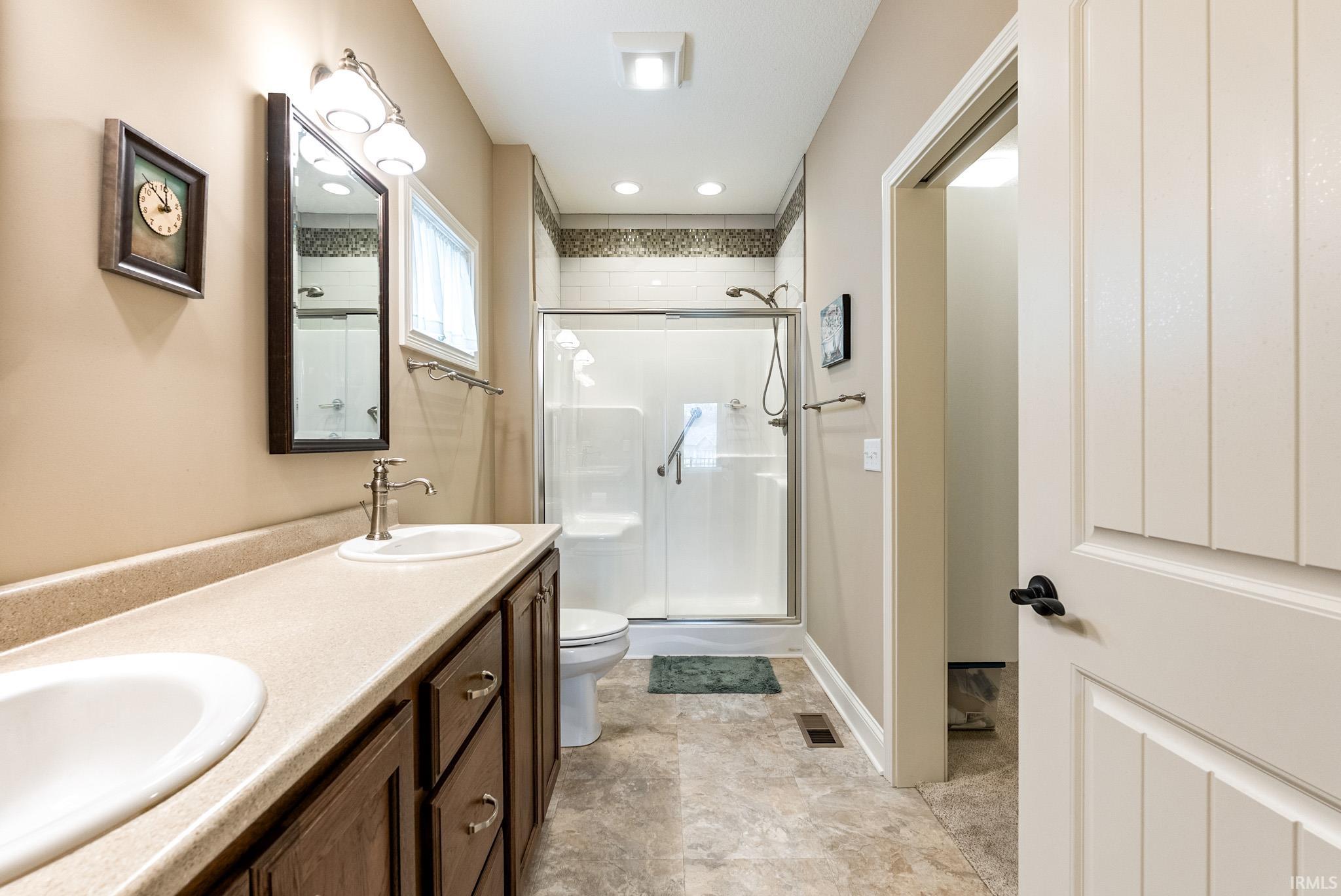 Full bathroom with a stall shower and double vanity
