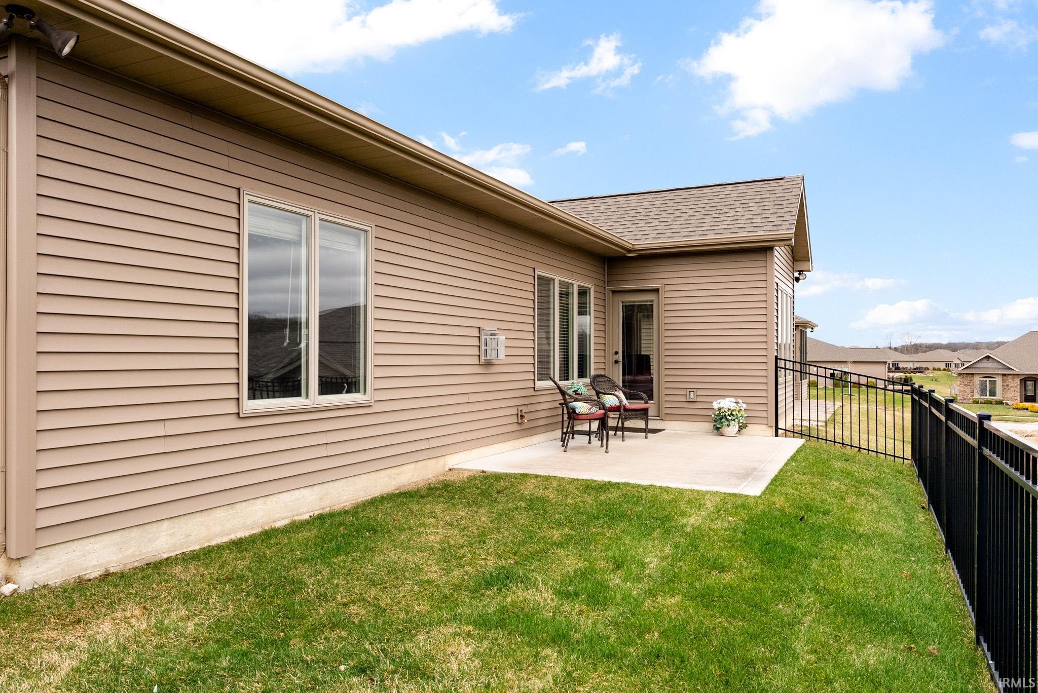 Back of house with a patio area and a shingled roof