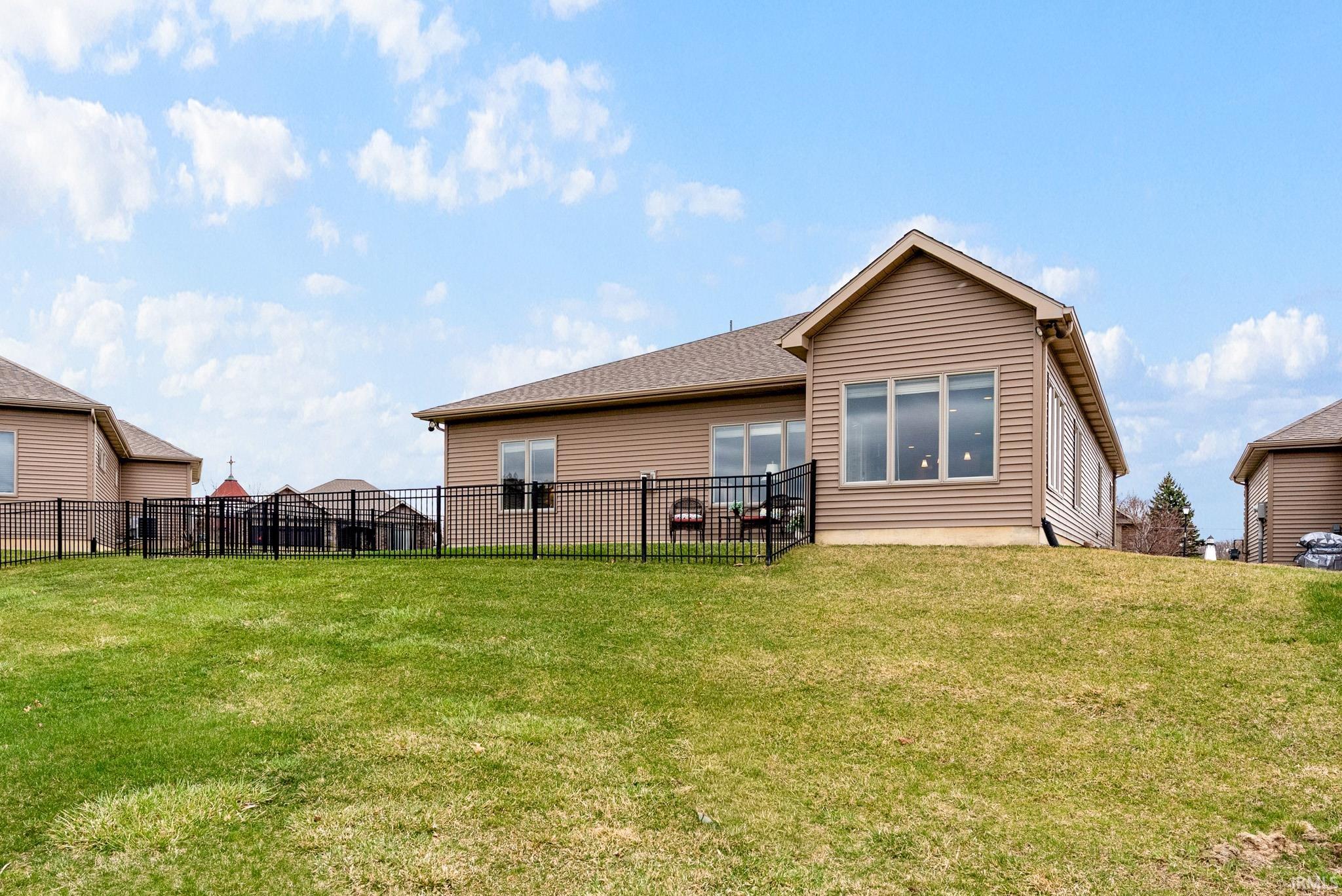 Rear view of property with a lawn and roof with shingles